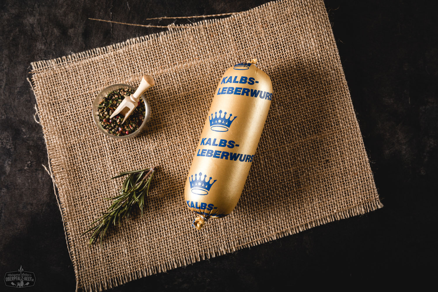 Kalbsleberwurst im Naturdarm – Delikate Portionsgröße aus der Oberpfalz Kalbfleisch-Leberwurst in Portionsgröße – vakuumverpackte, zylindrische Wurst mit heller, glatter Oberfläche, auf weißem Hintergrund liegend; Produkt der Marke Oberpfalz Beef.