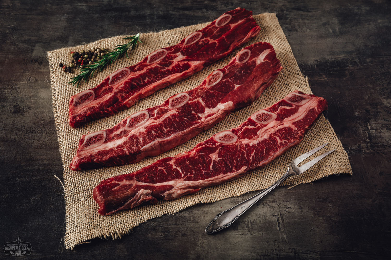 Gegrillte koreanische Short Ribs vom Oberpfalz-Rind auf dunklem Untergrund, saftig glasiert mit dunkler Marinade, angerichtet mit Frühlingszwiebeln und Sesamsamen – zartes Rindfleisch mit knuspriger Kruste in authentischem Korean-Style BBQ.