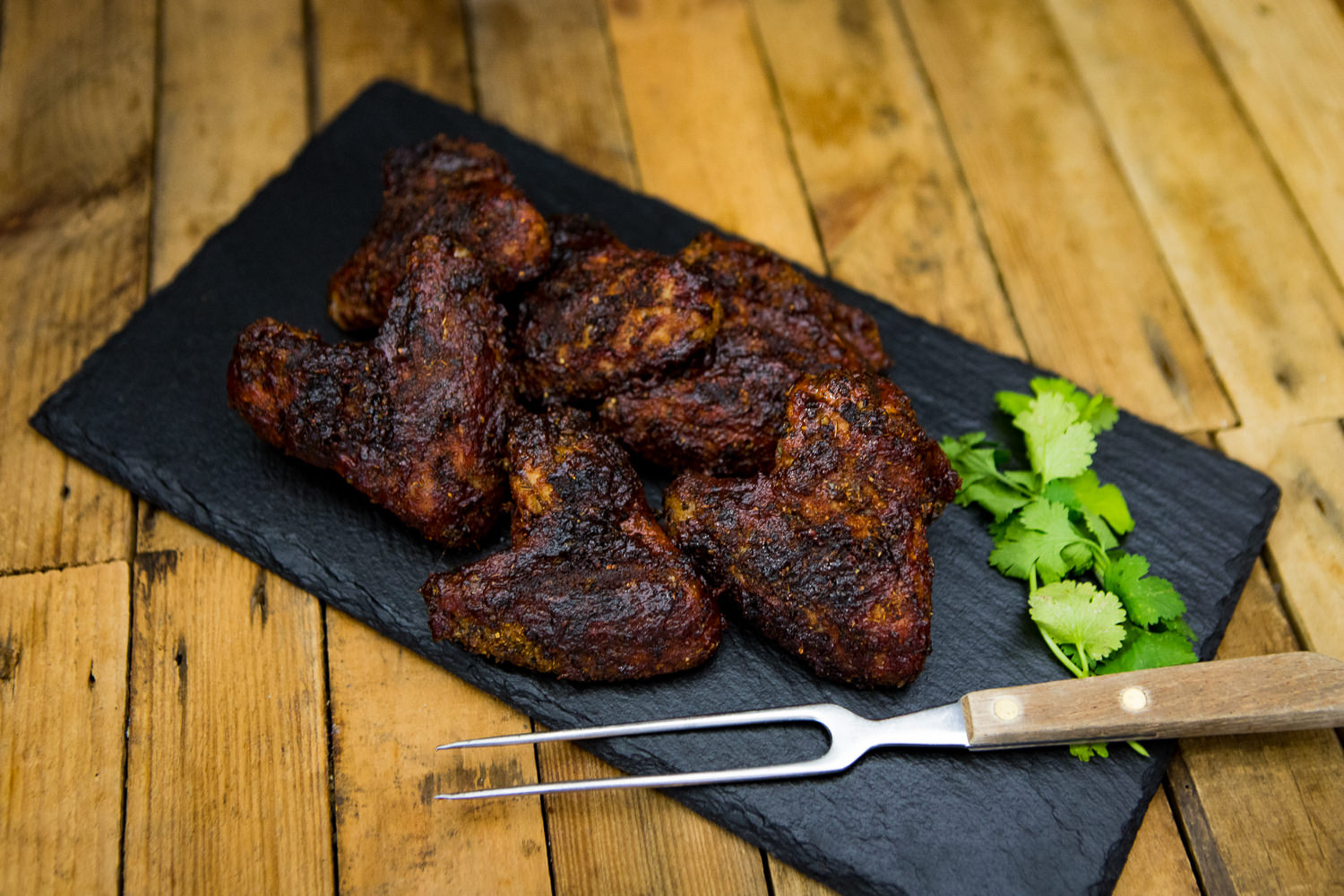 Gegrillte Chicken Wings vom Oberpfälzer Bauernhähnchen auf Holzplatte – knusprig & saftig Gegrillte Chicken Wings vom Oberpfälzer Bauernhähnchen, knusprig gebräunt und saftig angerichtet auf einem rustikalen Schneidebrett mit frischen Rosmarinzweigen – hochwertiges Geflügelfleisch aus regionaler Aufzucht.