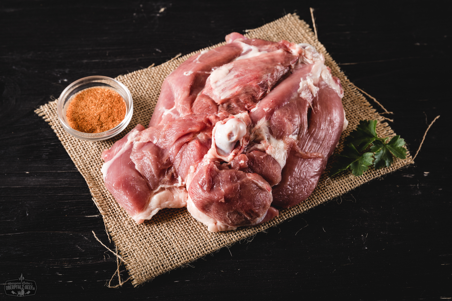 Frische Putenoberkeule roh – hochwertiges Geflügelfleisch aus der Oberpfalz Frische, rohe Putenoberkeule ohne Haut auf einem dunklen Holzbrett angerichtet, umgeben von Gewürzen wie Rosmarin, Knoblauch und bunten Pfefferkörnern – ideal für Braten oder Grillgerichte.