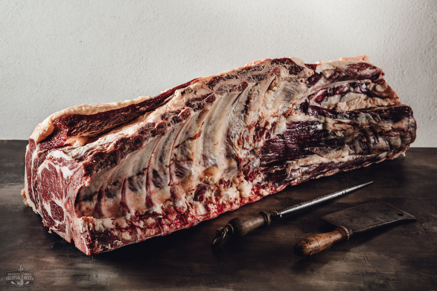 Ganzer Rinderrücken mit Knochen und Filet zum Selberreifen vom Oberpfalz-Rind – Premium Beef aus Bayern Rohes Rinderrückenteil mit Knochen und Filet vom Oberpfalz-Rind, auf einem dunklen Untergrund präsentiert – ideal zum Selberreifen oder Dry-Aging; frisches Premium-Fleisch für Fleischliebhaber und Metzgereien.