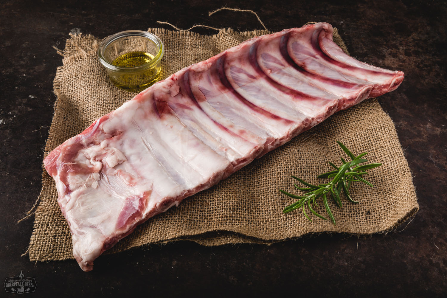 Zarte Kalbsrippen vom Oberpfälzer Milchkalb frisch gegrillt Saftig gegrillte Rippchen vom Oberpfälzer Milchkalb auf Holzbrett angerichtet, mit knuspriger Kruste, frischen Kräutern garniert und in rustikalem Umfeld serviert – hochwertiges Kalbfleisch für BBQ-Liebhaber.