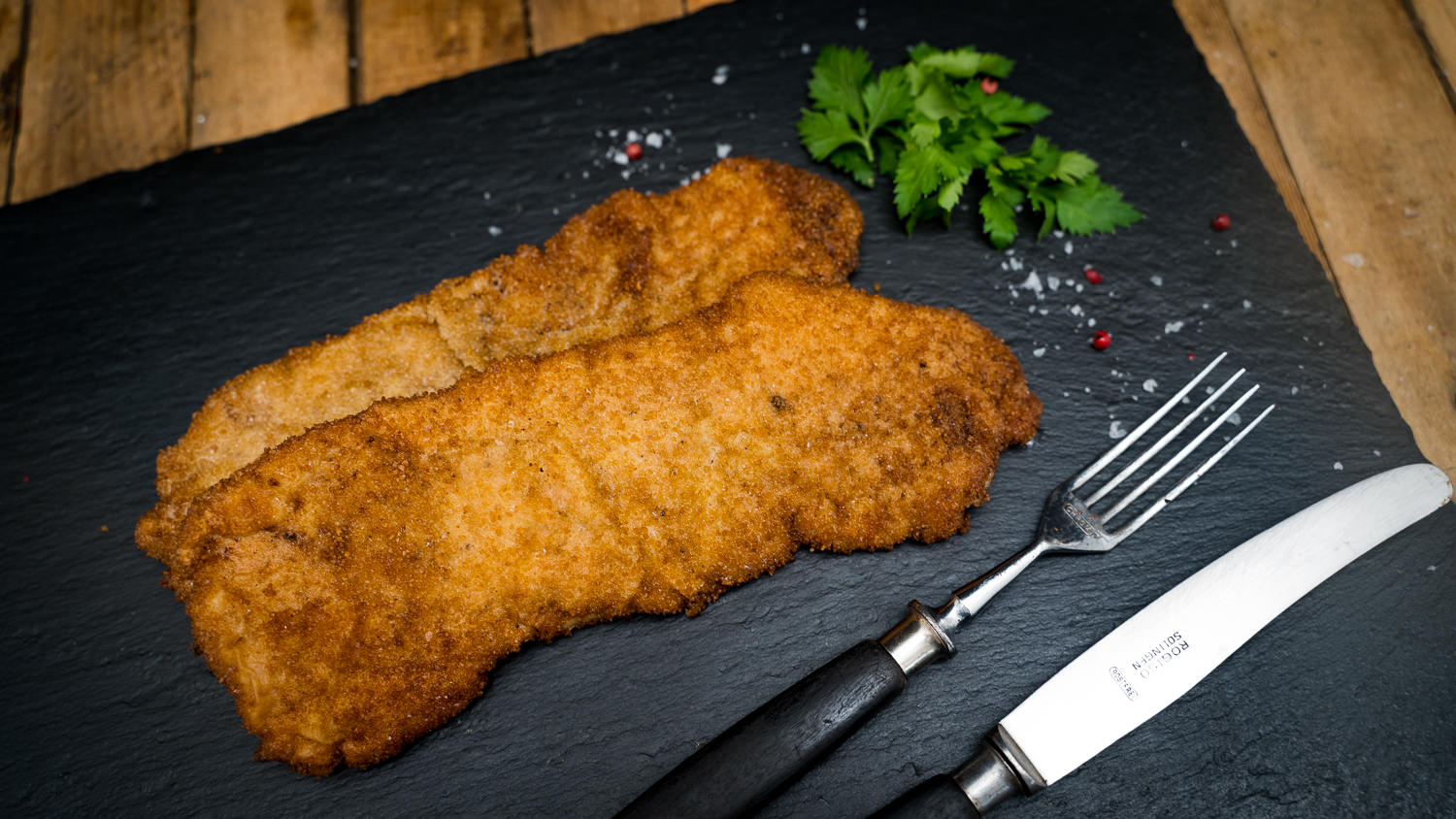 Schnitzel vom Oberpfälzer Milchkalb – Zartes Kalbfleisch regional genießen Goldbraun paniertes Schnitzel vom Oberpfälzer Milchkalb auf weißem Teller, serviert mit Zitronenscheibe, knusprigen Bratkartoffeln und frischer Petersilie – traditionelle bayerische Spezialität, frisch zubereitet und regional gekocht.