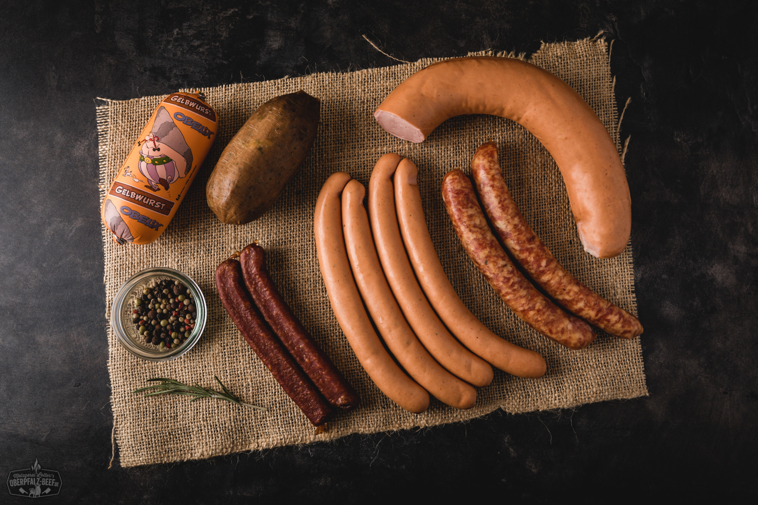 Notfallpaket Wurst – Hausgemachte Dosenwurst aus der Oberpfalz kaufen Bild eines Notfallpakets mit verschiedenen Arten von Wurst, das vakuumverpackt und auf einer rustikalen Holzoberfläche präsentiert wird, ideal für Liebhaber von Oberpfälzer Fleischspezialitäten.
