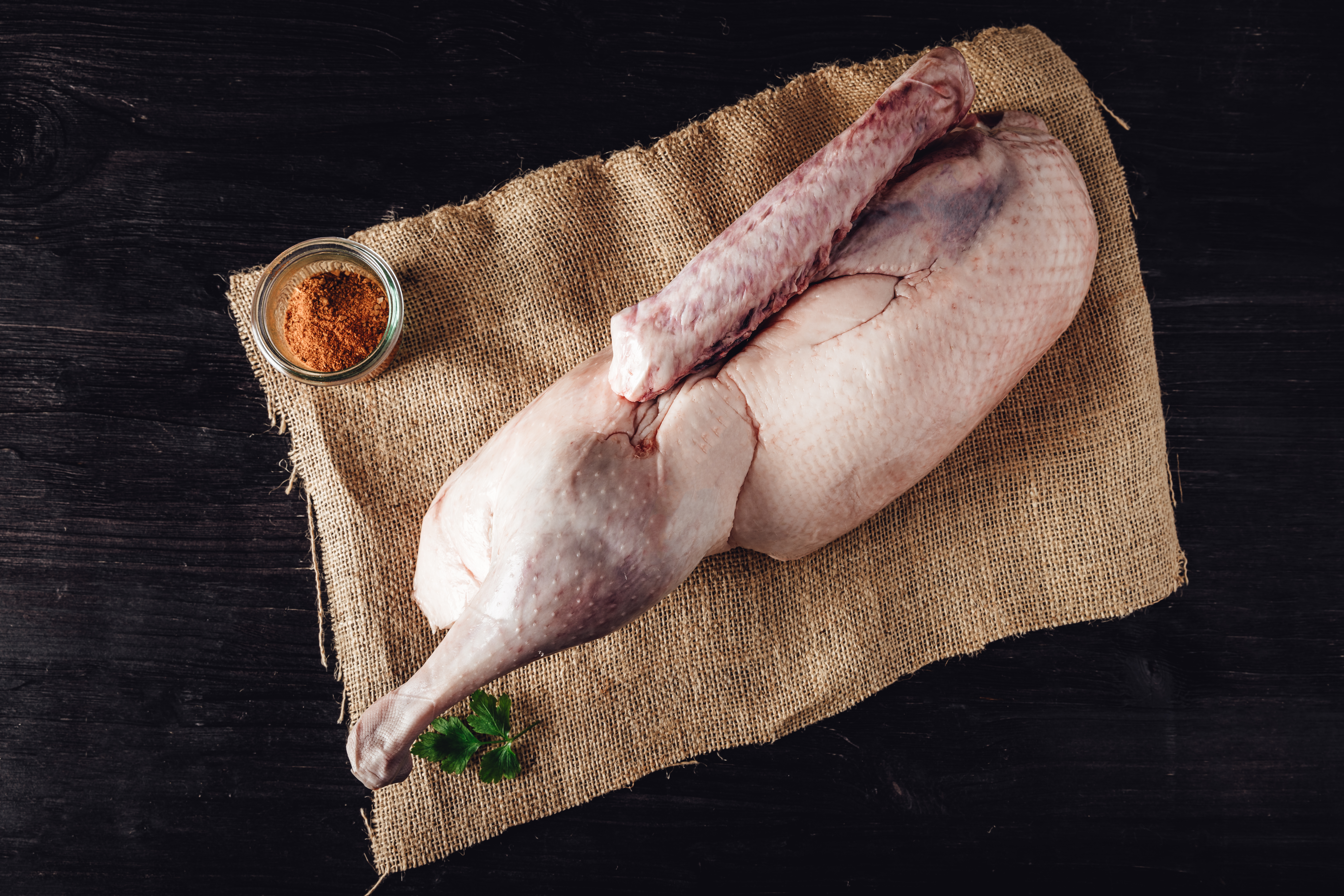 Halbe Oberpfälzer Weihnachtsgans knusprig gebraten auf Bratensauce mit Kloß und Blaukraut Halbe, knusprig gebratene Oberpfälzer Weihnachtsgans auf Holzbrett angerichtet, serviert mit Orangenscheiben, frischem Rosmarin und Bratensoße – traditionelle bayerische Festtagsspezialität in rustikalem Ambiente.