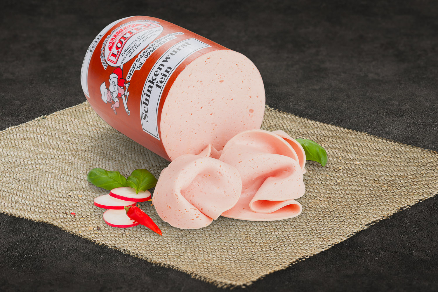 Fein geschnittene Schinkenwurst auf weißem Teller – Delikatess-Aufschnitt Fein geschnittene Schinkenwurst in dünnen, gleichmäßigen Scheiben auf einem Holzbrett angerichtet, begleitet von frischer Petersilie – ideal für Brotzeit oder Frühstück; hochwertige Präsentation typisch für traditionelle Metzgerkunst.