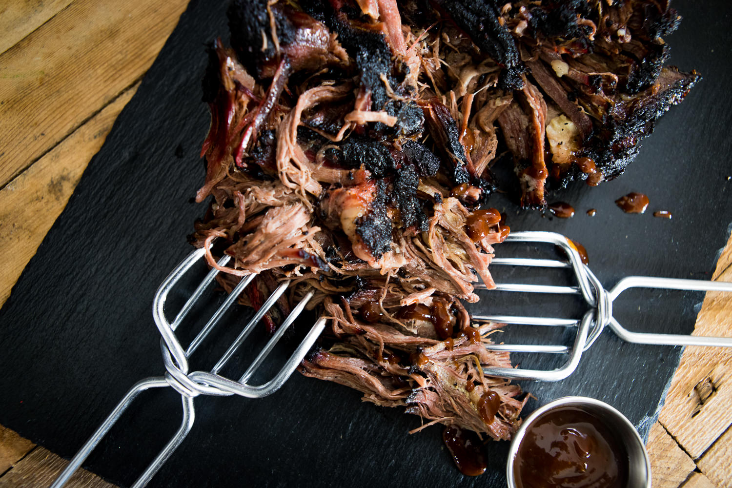Pulled Beef Wet Aged vom Oberpfalz-Rind – Zartes Rindfleisch für BBQ und Burger Rohes Suppenfleisch aus der Wade vom Oberpfalz-Rind auf einem dunklen Schneidebrett, umgeben von frischem Gemüse wie Karotten, Lauch und Sellerie, dekorativ angerichtet zur Zubereitung einer traditionellen Rinderbrühe.