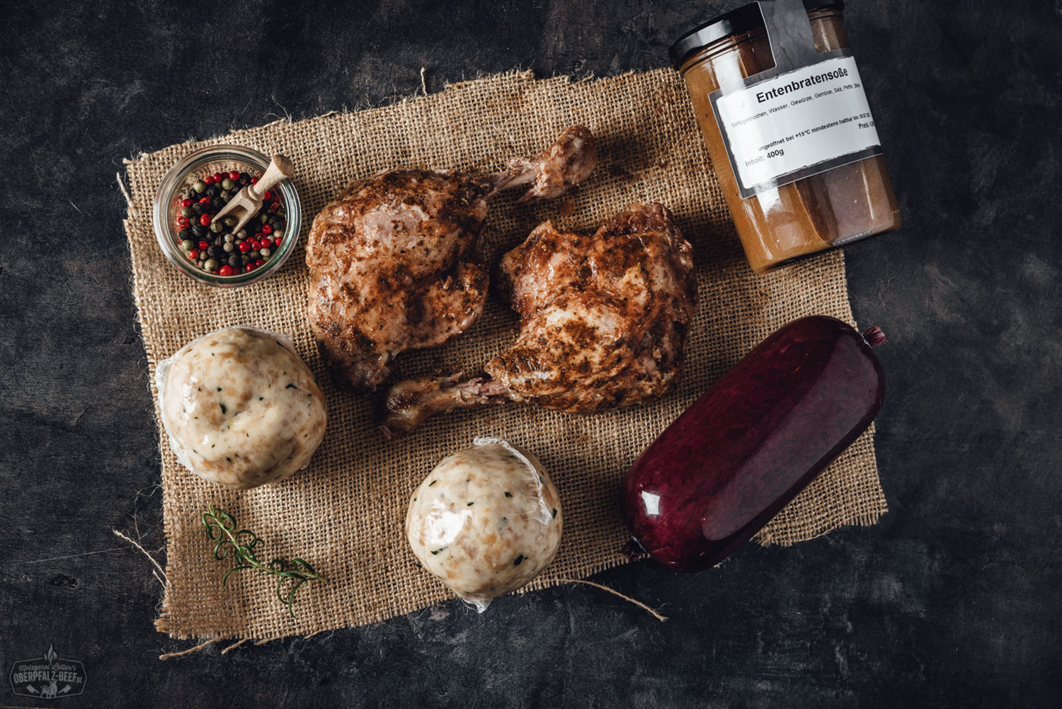 Knusprig gebratene Entenkeule aufgeschnitten mit goldbrauner Haut, serviert in brauner Schale mit Blaukraut und Kartoffelknödel, rustikale Präsentation aus der Oberpfalz – traditionelle bayerische Entenspezialität.