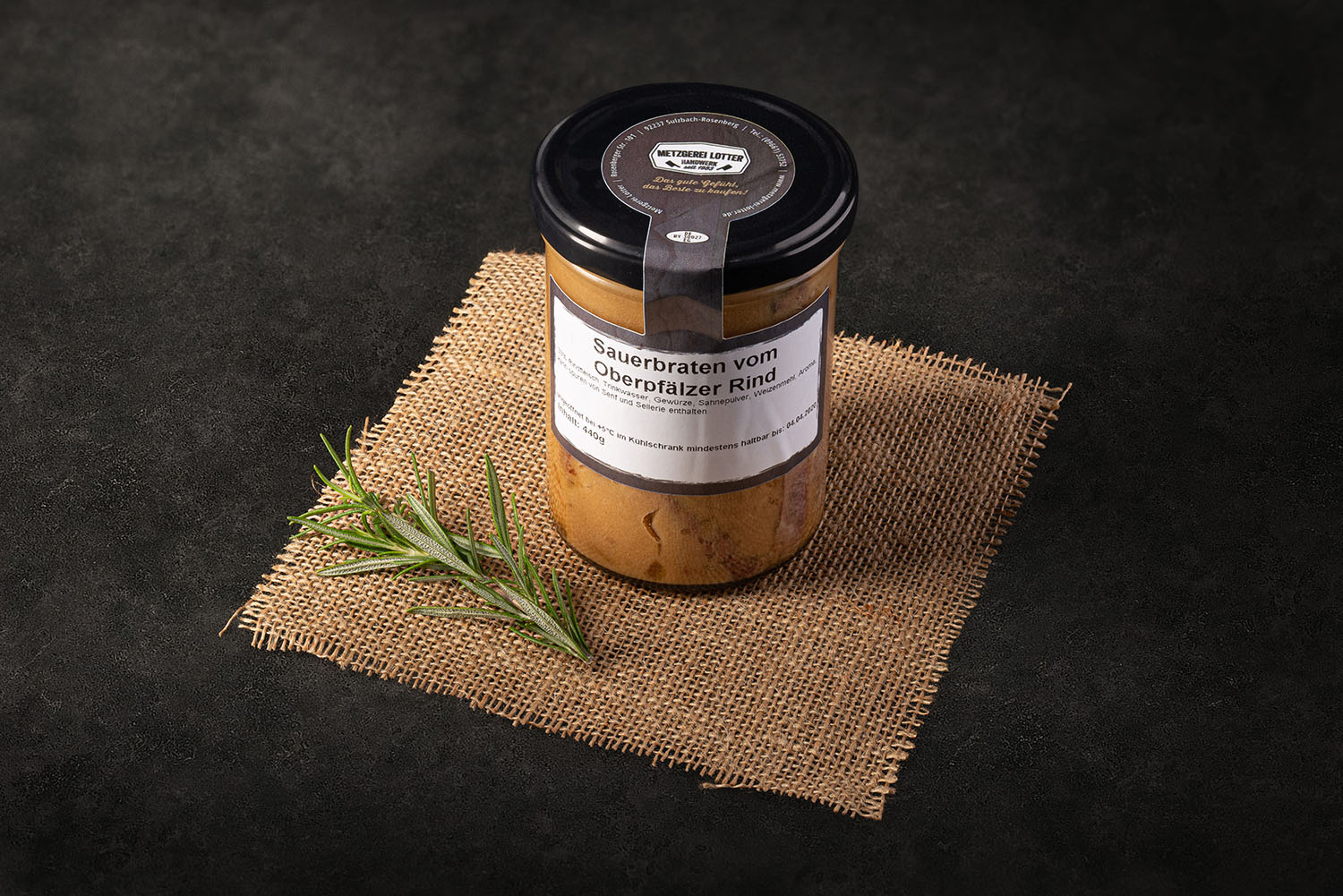 Sauerbraten im Glas – Nahaufnahme eines traditionellen deutschen Sauerbratens in klar verschlossenem Einmachglas, sichtbar mit dunkler, würziger Soße und Fleischstücken, auf hellem Hintergrund präsentiert – Hausmannskost, haltbar gemacht.