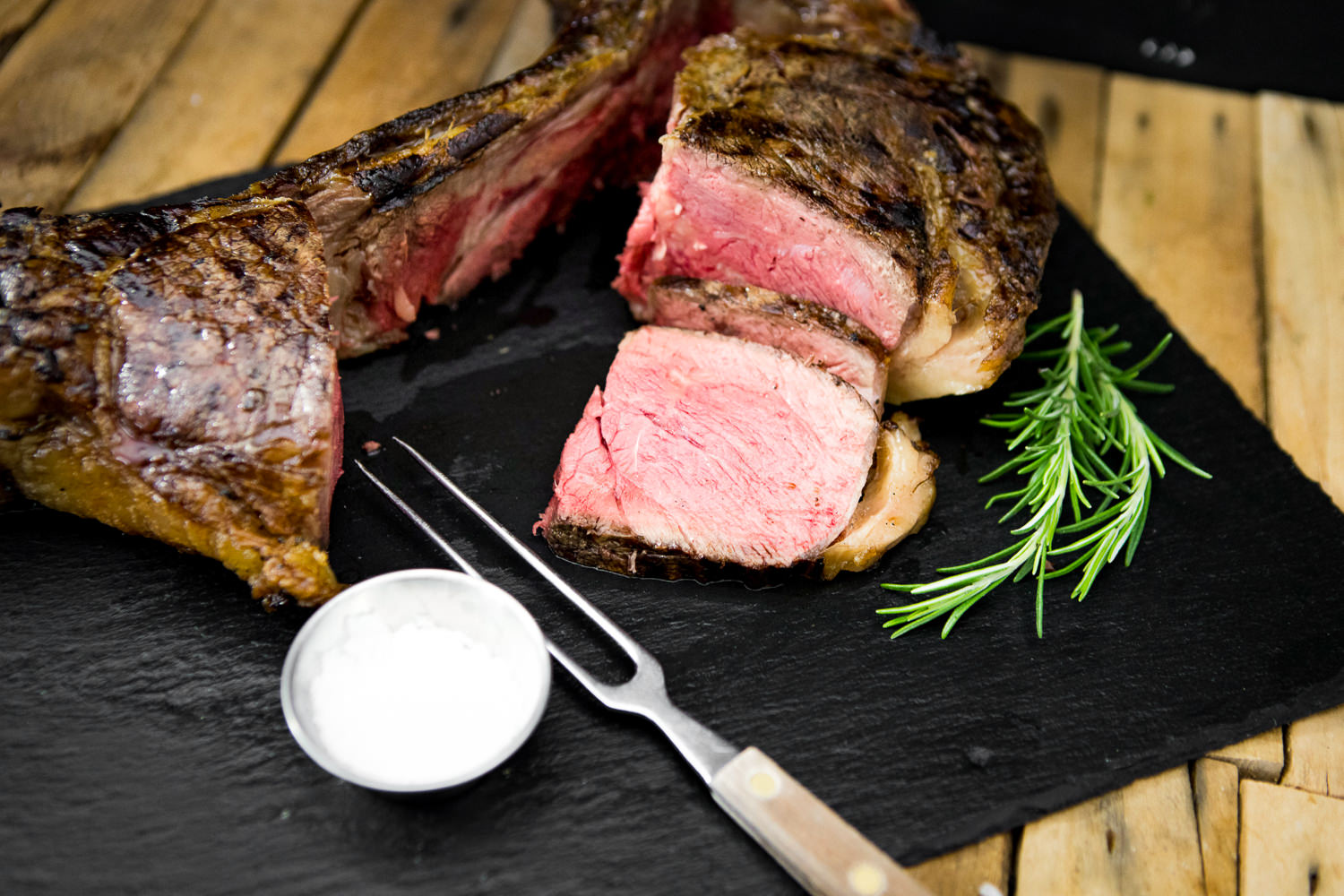 Dry Aged Tomahawk Steak vom Oberpfälzer Rind auf Holzbrett angerichtet Tomahawk-Steak dry aged vom Oberpfalz-Rind auf Holzbrett, saftig gebraten mit sichtbarer Marmorierung, dunkler Kruste und langem Knochen, servierbereit vor rustikalem Hintergrund – hochwertiges Premium-Rindfleisch aus regionaler Zucht.