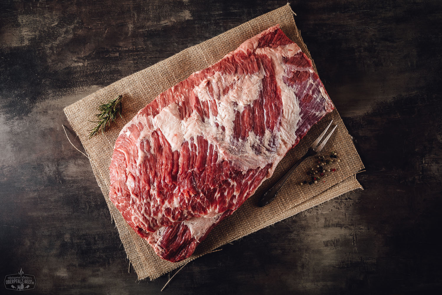 Nahaufnahme eines saftig gegarten Beef Briskets vom Oberpfalz-Rind auf Holzbrett, mit deutlich sichtbarer feiner Marmorierung, zart rosa Fleischkern und knuspriger Kruste – perfekt geeignet für BBQ, Grill oder Smoker.