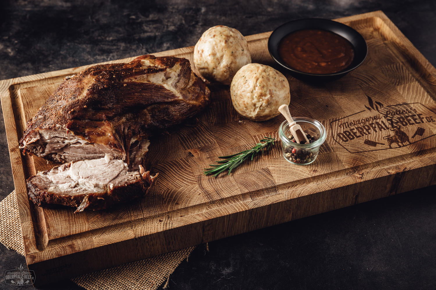 Sous-Vide Schweinebraten vom Hals – Vorgegart, zart & saftig in der Box Sous-vide gegarter Oberpfälzer Kalbsrollbraten in geöffneter Gourmet-Box, vakuumverpackt mit frischen Kräutern, auf Holztisch präsentiert – hochwertiges, fertig zubereitetes Fleischprodukt für Feinschmecker.