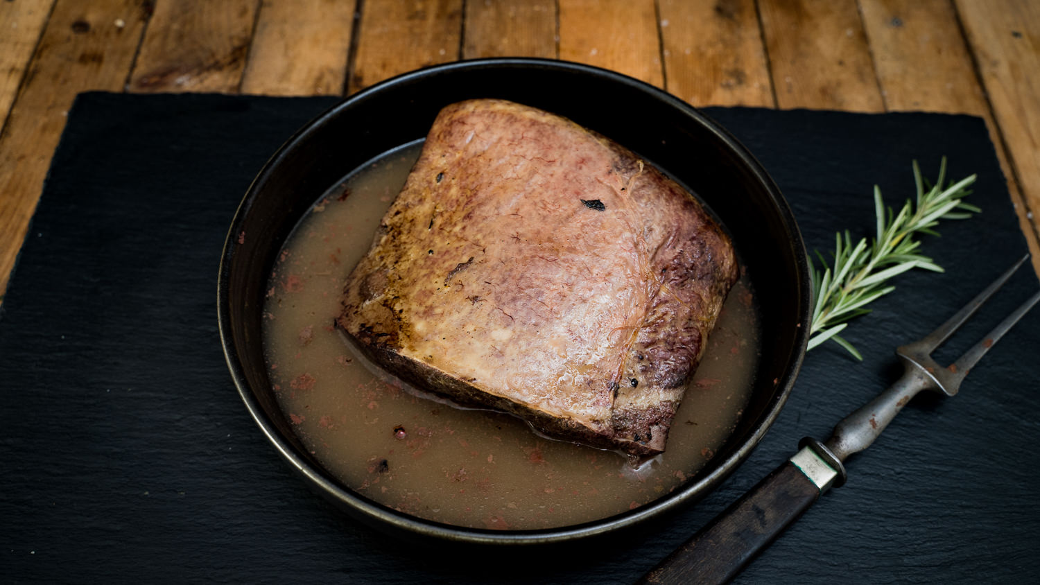 Milz vom Oberpfälzer Landschwein – frisches Schweineinnereienfleisch aus regionaler Aufzucht Rohe, frisch zugeschnittene Milz vom Oberpfälzer Landschwein auf einem dunklen Schneidebrett, umgeben von grobem Salz, frischen Kräutern und Gewürzen – hochwertiges Schweinefleisch aus regionaler Aufzucht, ideal für traditionelle Rezepte.