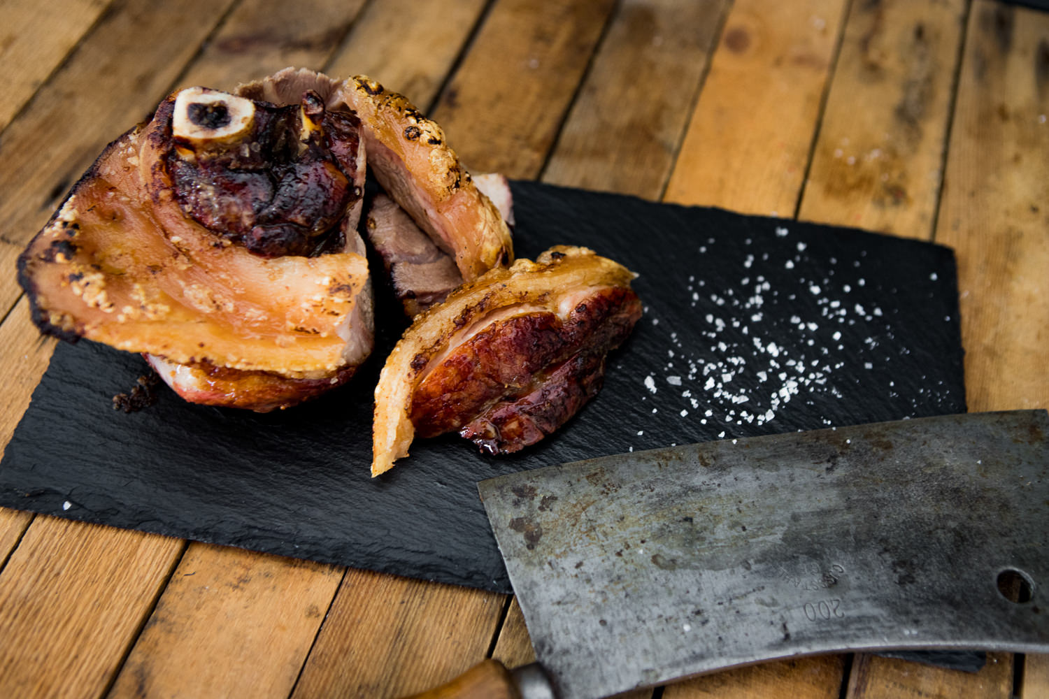 Gegrillte Hintere Haxe vom Rind – Traditionelles BBQ aus Bayern Gegrillte bayerische Hintere Haxe auf einem Holzbrett angerichtet, knusprige Haut goldbraun gebraten, mit Sauerkraut, Senf und frischer Petersilie garniert – traditionelles bayerisches Grillgericht im rustikalen Stil.