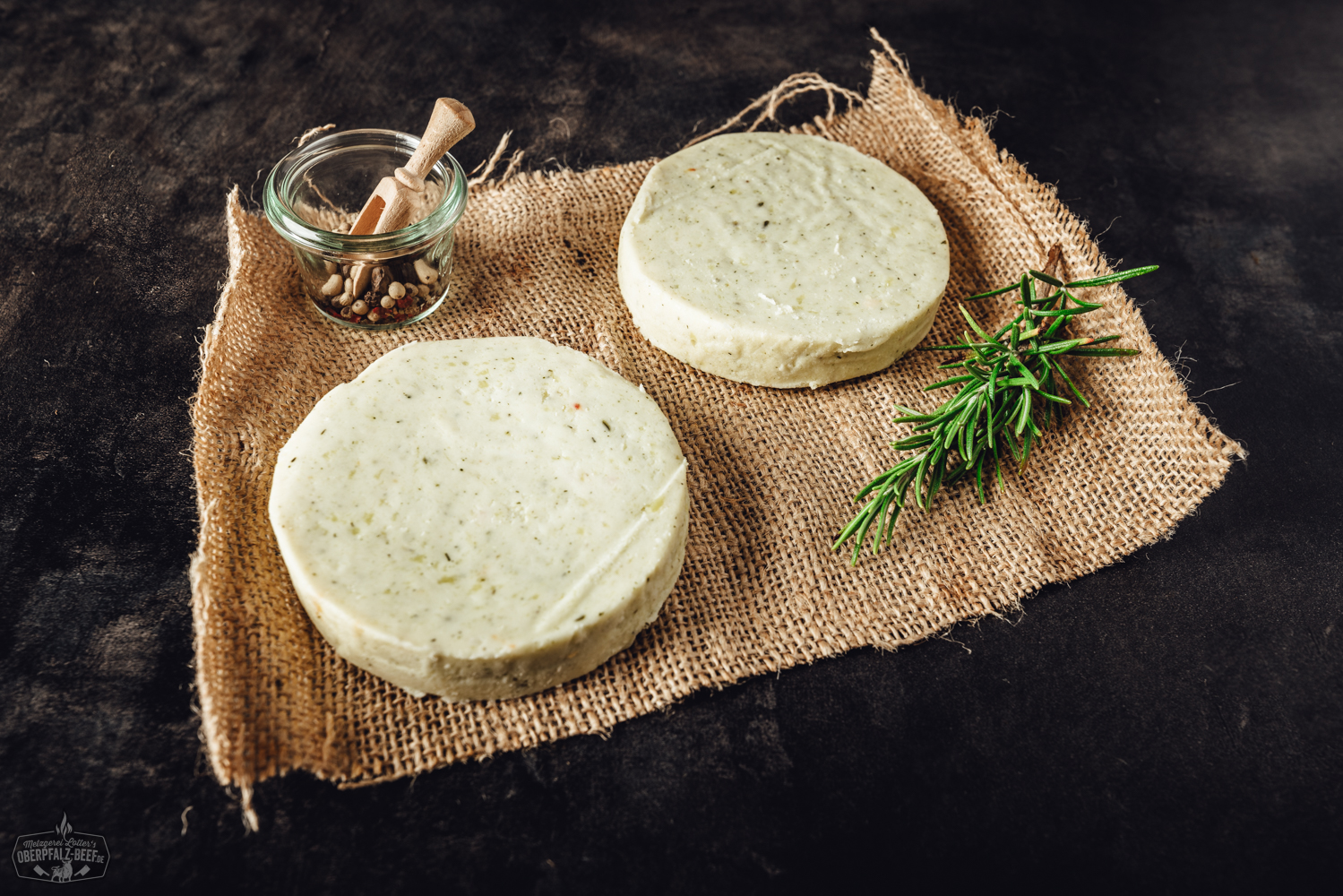 Grillkäse mit Kräutern auf Holzteller – vegetarische Grillalternative Gegrillter Grillkäse mit goldbrauner Kruste, serviert auf dunklem Holzbrett neben roten Peppadew-Chili-Schoten, frischen Kräutern und Meersalz – hochwertige Nahaufnahme für BBQ und vegetarische Grillrezepte.