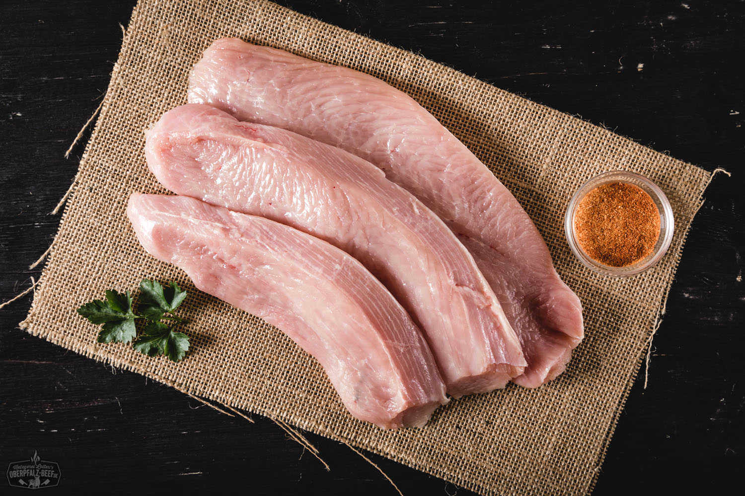 Schnitzel von der Oberpfälzer Bauernpute – Regionales Geflügelfleisch in bester Qualität Gebratenes Puten-Schnitzel aus Oberpfälzer Bauernhaltung auf Holzbrett angerichtet, goldbraun paniert, dazu frische Kräuter und Zitronenspalte – hochwertige Fleischspezialität aus regionaler Aufzucht.