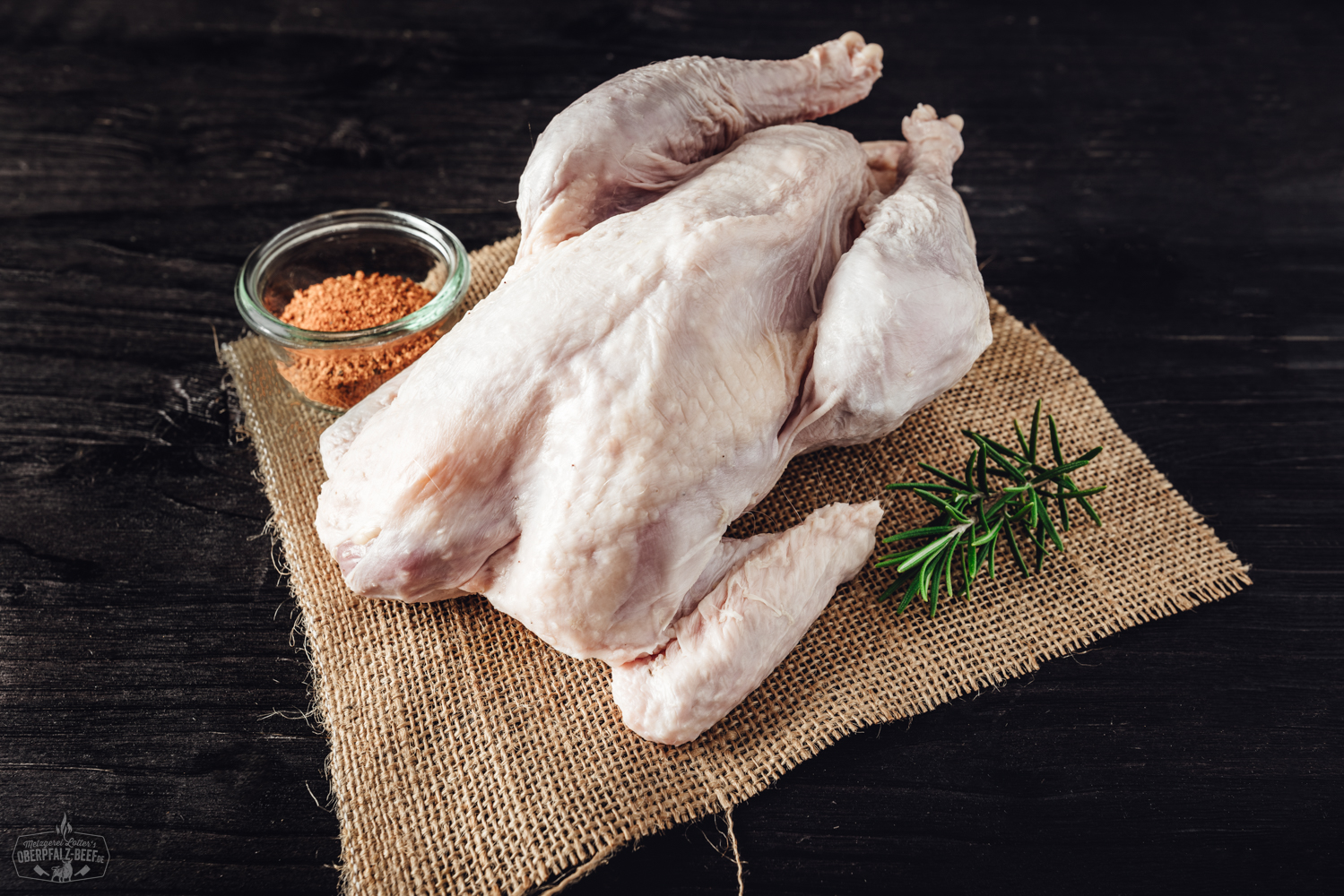 Suppenhuhn vom Oberpfälzer Bauernhähnchen auf Holzbrett mit frischen Kräutern und Gemüse, hochwertige regionale Fleischqualität, Oberpfalz Beef.