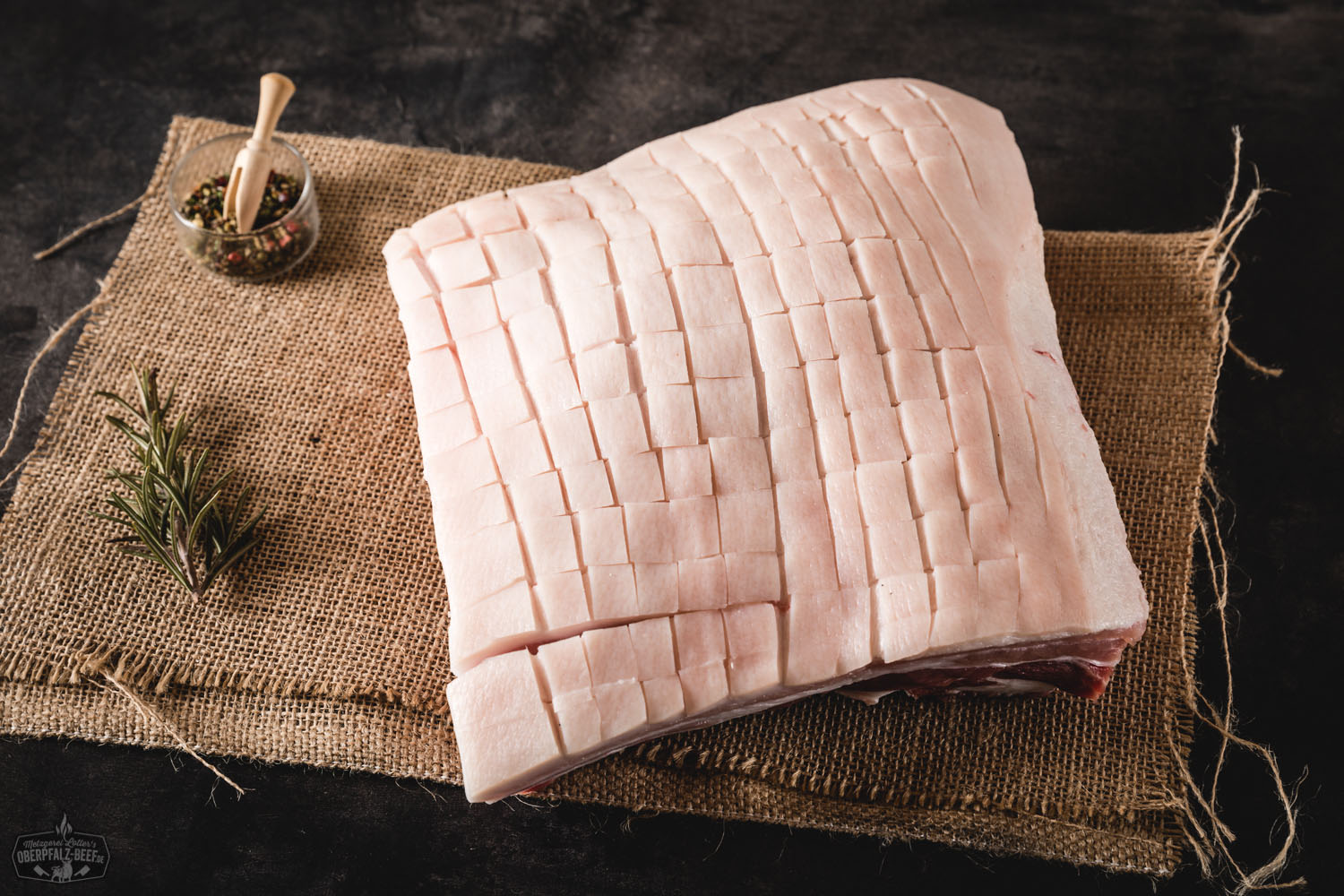 Fein geschnittener Trüffelschinken auf dunklem Holzbrett angerichtet, mit sichtbaren Trüffelstückchen im zarten, marmorierten Fleisch; im Hintergrund ein Messer – hochwertige Delikatesse für Feinschmecker.