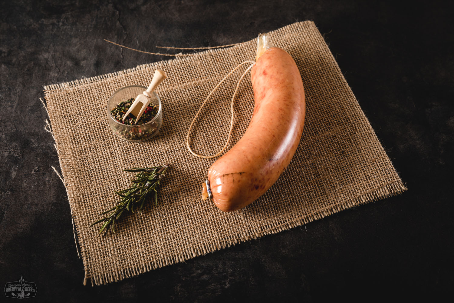 Mittelgrobe Mettwurst aus der Oberpfalz – herzhaft geräucherte Rohwurst Mittelgrobe Mettwurst in Scheiben geschnitten auf einem rustikalen Holzbrett, angerichtet mit frischen Kräutern und einer Brotscheibe im Hintergrund – typisch deutsche Wurst-Spezialität aus der Oberpfalz, ideal für Brotzeit oder kalte Platten.