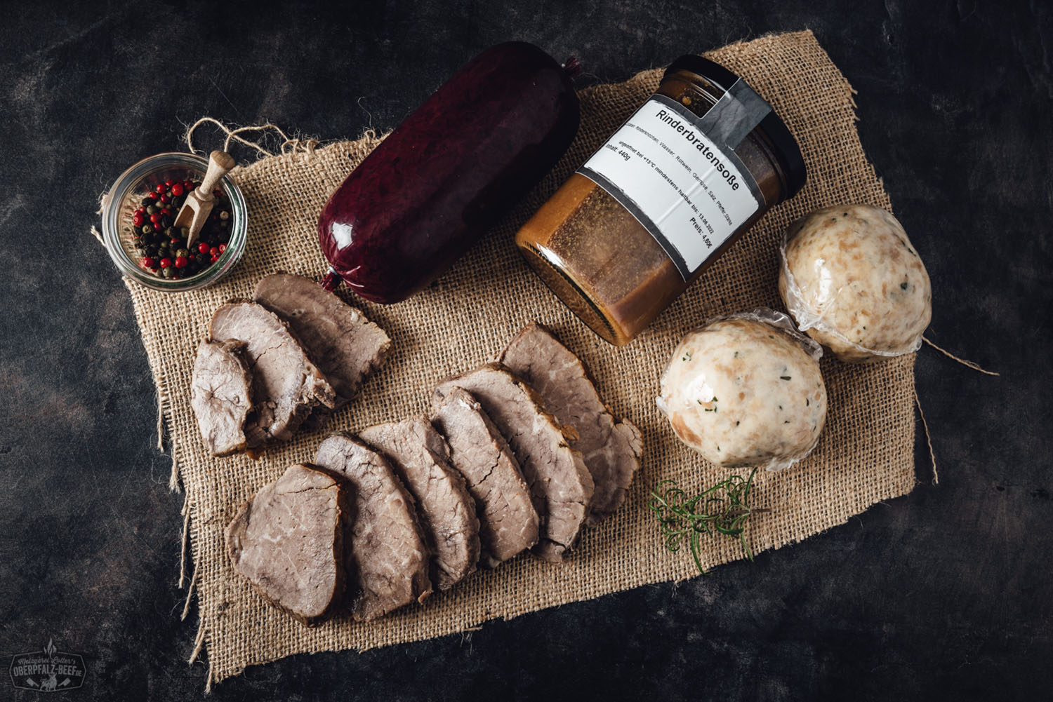 Oberpfälzer Rinderbraten-Box mit regionalem Rindfleisch – Frische Fleischbox online bestellen Oberpfälzer Rinderbratenbox mit vakuumverpacktem Rindfleisch auf hellem Holzuntergrund, dekoriert mit frischen Kräutern, Gewürzen und Gemüse; hochwertige Fleischbox für regionalen Rinderbraten aus der Oberpfalz.