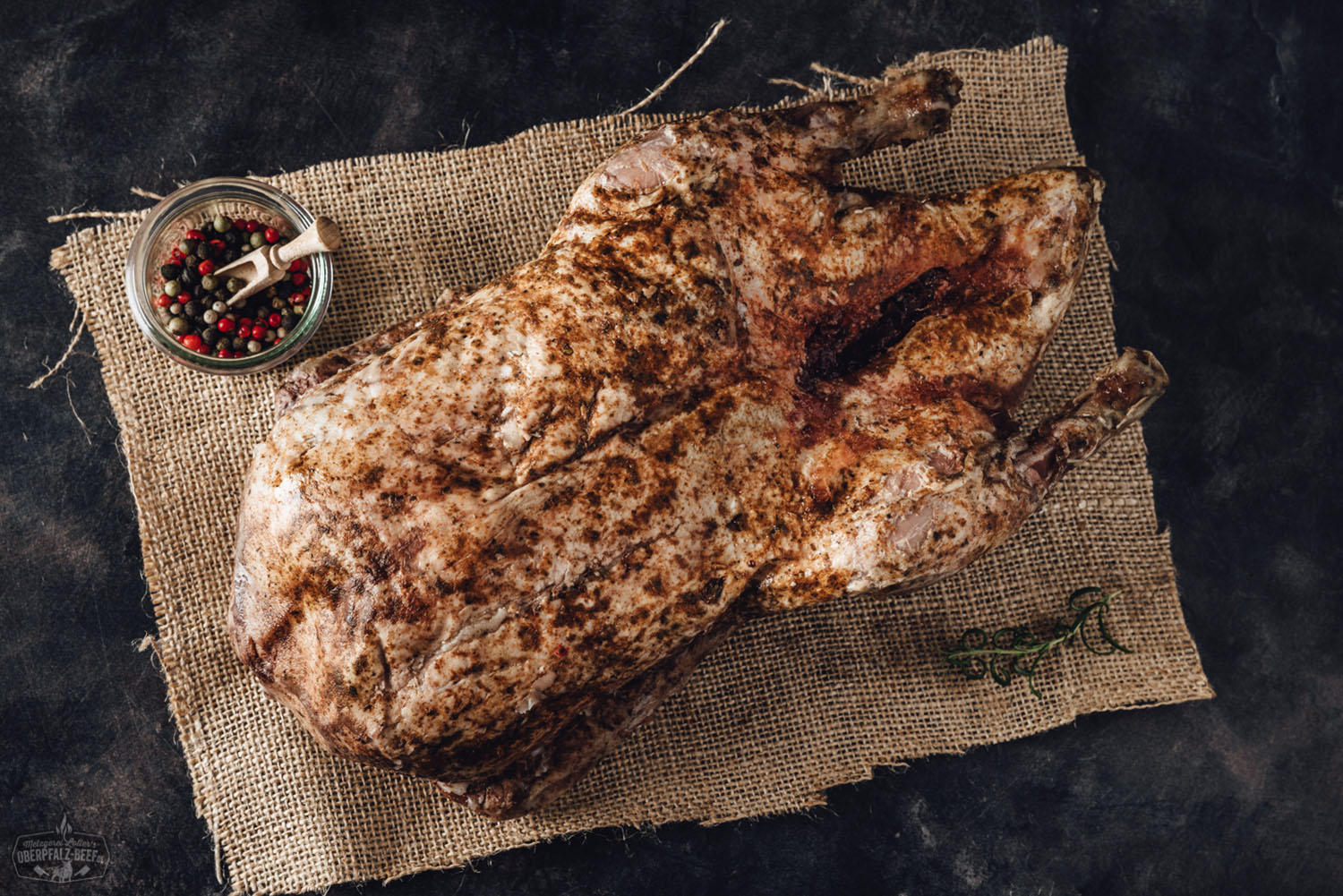 Sous-vide gegarte Oberpfälzer Bauernente im Ganzen – zart & knusprig vorbereitet Vorgegarte Oberpfälzer Bauernente, goldbraun gebraten und in Hälften zerteilt, angerichtet auf einem dunklen Holzbrett mit rustikaler Optik; umgeben von Rosmarinzweig und Gewürzen – traditionelle deutsche Spezialität, ideal für Sous-vide-Zubereitung.