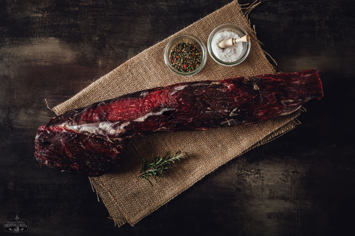 Dry Aged Rinderfilet am Stück von der alten Kuh – Premiumqualität aus der Oberpfalz Dry Aged Rinderfilet am Stück von der alten Kuh, roh und marmoriert, auf dunklem Untergrund dekorativ präsentiert – hochwertiges Premiumfleisch aus artgerechter Weidehaltung.