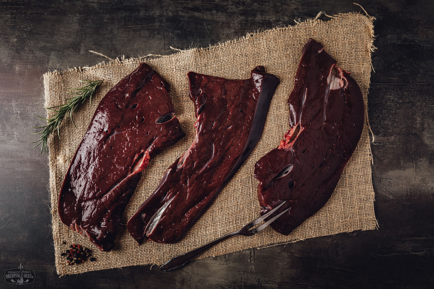 Frische Rinderscheibenleber vom Oberpfalz-Rind roh auf dunklem Untergrund angerichtet, deutlich sichtbare Fleischstruktur und saftige Textur, ideal zum Braten oder Schmoren.