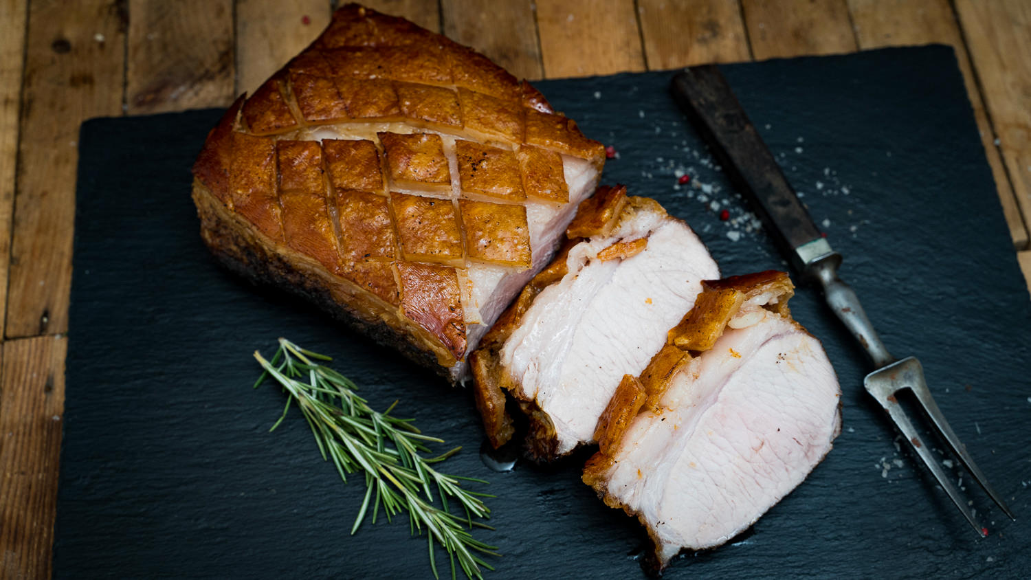 Dry Aged Kotelett vom Oberpfälzer Landschwein mit Schwarte – hochwertiges Schweinefleisch am Stück Ganzes Dry Aged Kotelett vom Oberpfälzer Landschwein mit Knochen und Schwarte, roh und sorgfältig portioniert auf dunklem Untergrund präsentiert – hochwertige Fleischqualität für Grill und Steak-Liebhaber.