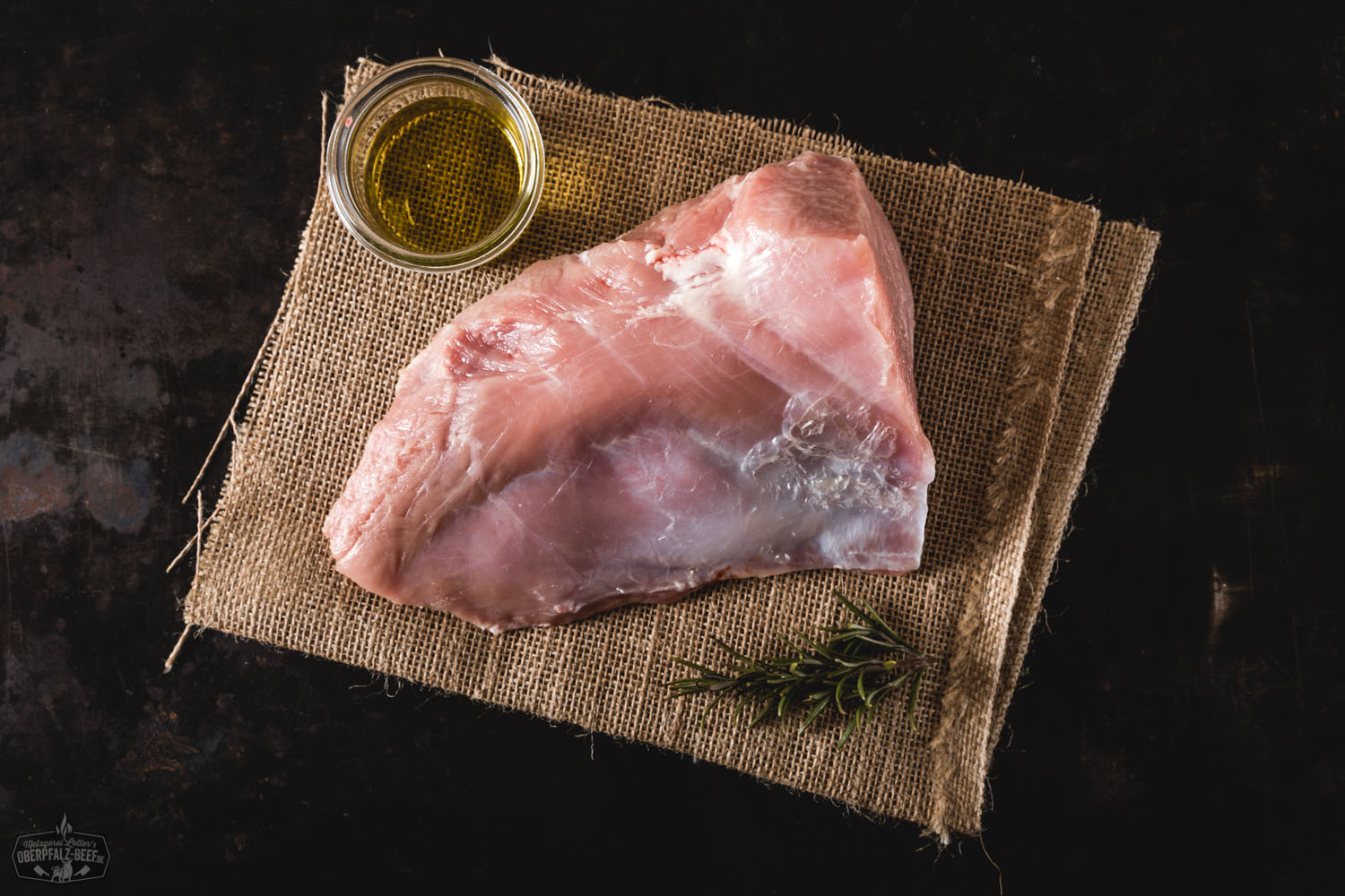 Rosa gebratener Tafelspitz vom Oberpfälzer Milchkalb, saftig aufgeschnitten und auf einem dunklen Holzbrett angerichtet, garniert mit Rosmarinzweig, Meersalz und buntem Pfeffer – hochwertiges Kalbfleisch in Premium-Qualität für Feinschmecker.