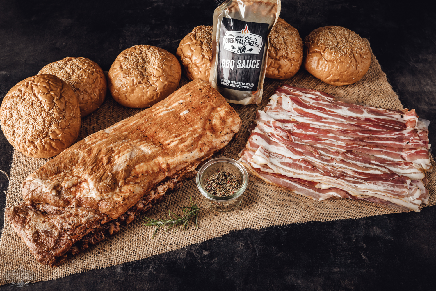 Sous-vide vorgegarte Spare Ribs im St. Louis Style in geöffneter Verpackung auf Holzuntergrund, saftig glasiert mit BBQ-Sauce, servierfertig angerichtet als Grillgericht mit Fleischstruktur gut sichtbar.