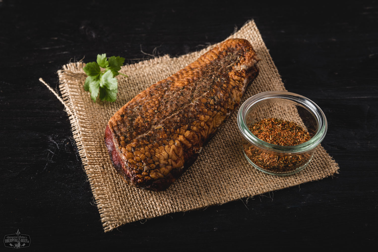 Aufgeschnittenes, geräuchertes Brustfilet von der Oberpfälzer Bauernente auf dunklem Holzbrett, angerichtet mit frischen Kräutern und Gewürzen – hochwertige Delikatesse der regionalen Entenküche.