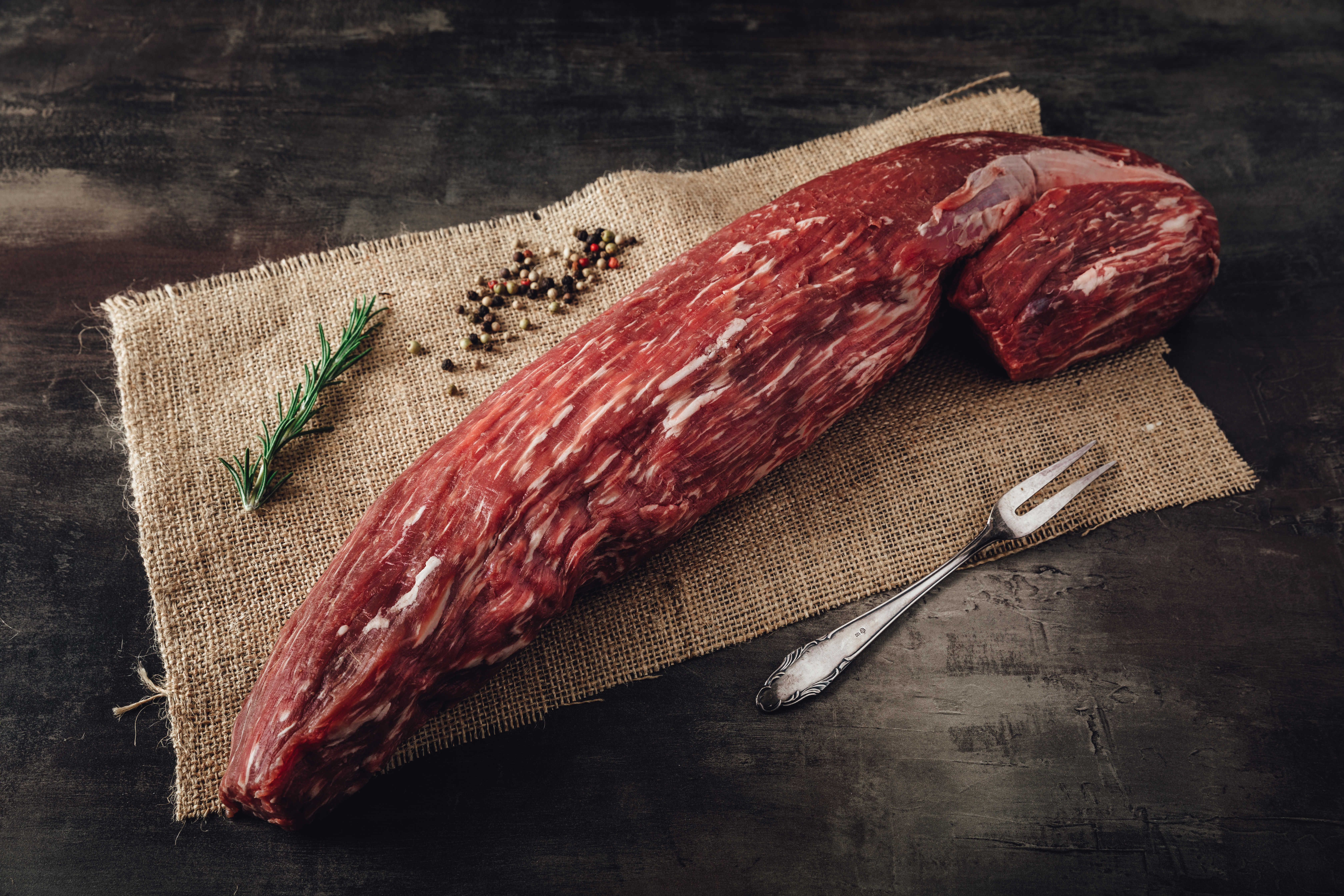 Ganzes und halbiertes Rinderfilet von Oberpfalz Beef - Hochwertiges Fleischprodukt Bild zeigt ein ganzes und ein halbiertes Rinderfilet von Oberpfalz Beef, auf einem Holzbrett präsentiert, ideal für hochwertige Fleischgerichte und Feinschmecker.