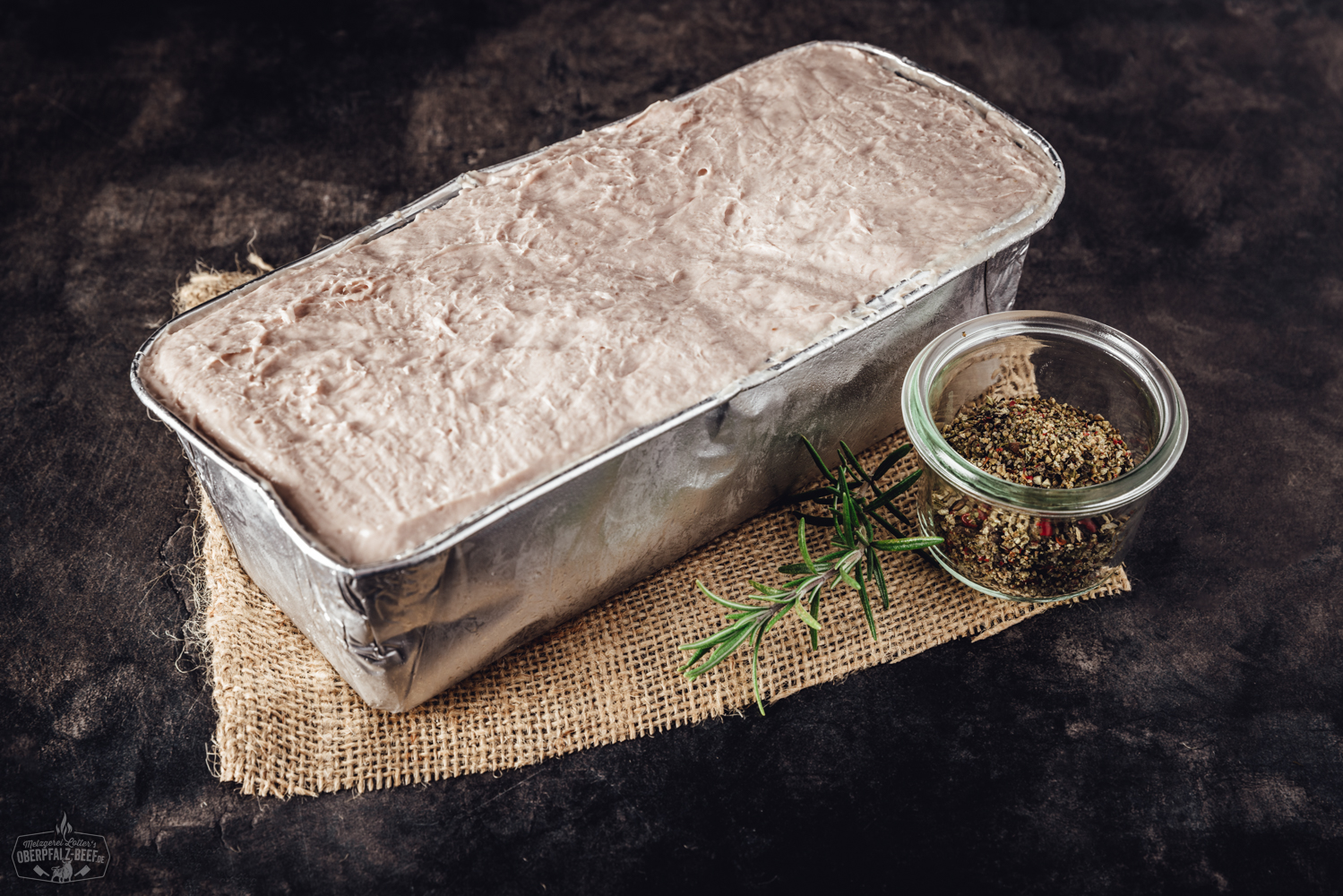 Oberpfälzer Leberkäse zum Selberaufbacken – traditioneller Fleischkäse aus Bayern Aufgeschnittener Oberpfälzer Leberkäse in goldbrauner Kruste auf weißem Teller mit Senf, angerichtet auf Holztisch – traditionelle bayerische Spezialität zum Selberaufbacken.