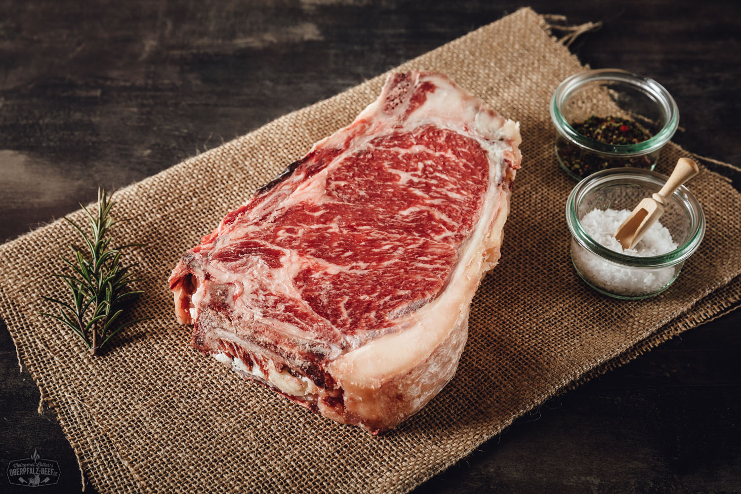 New York Cut Clubsteak Dry Aged von der alten Kuh – Premium Rindfleisch aus der Oberpfalz Dry Aged New York Cut Clubsteak von der alten Kuh roh auf Holzunterlage, marmoriertes Rindfleisch in Nahaufnahme mit sichtbarer Fettstruktur, hochwertiges Premium-Steak für Grill oder Pfanne.