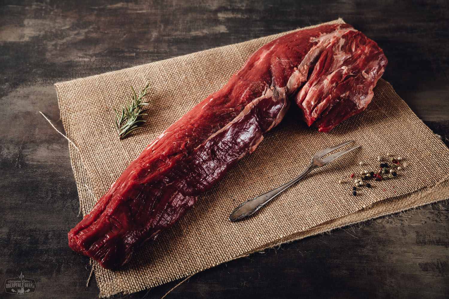 Ganzes, vakuumverpacktes Rinderfilet vom Oberpfalz-Rind in Wet Aged-Qualität auf dunklem Untergrund; das hochwertig marmorierte Fleisch liegt roh und ungeschnitten vor, etikettiert mit Herkunftsangaben – erstklassige Fleischqualität für Premium-Steaks.