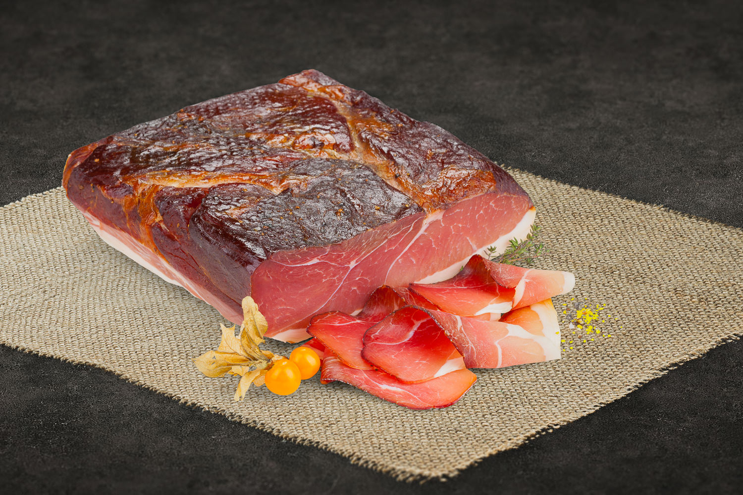 Aufgeschnittener Oberpfälzer Bauernschinken auf hellem Naturholzteller, serviert mit frischer Petersilie und Kirschtomaten, angerichtet auf rustikalem Holzuntergrund – traditioneller, regionaler Schinken aus Bayern.