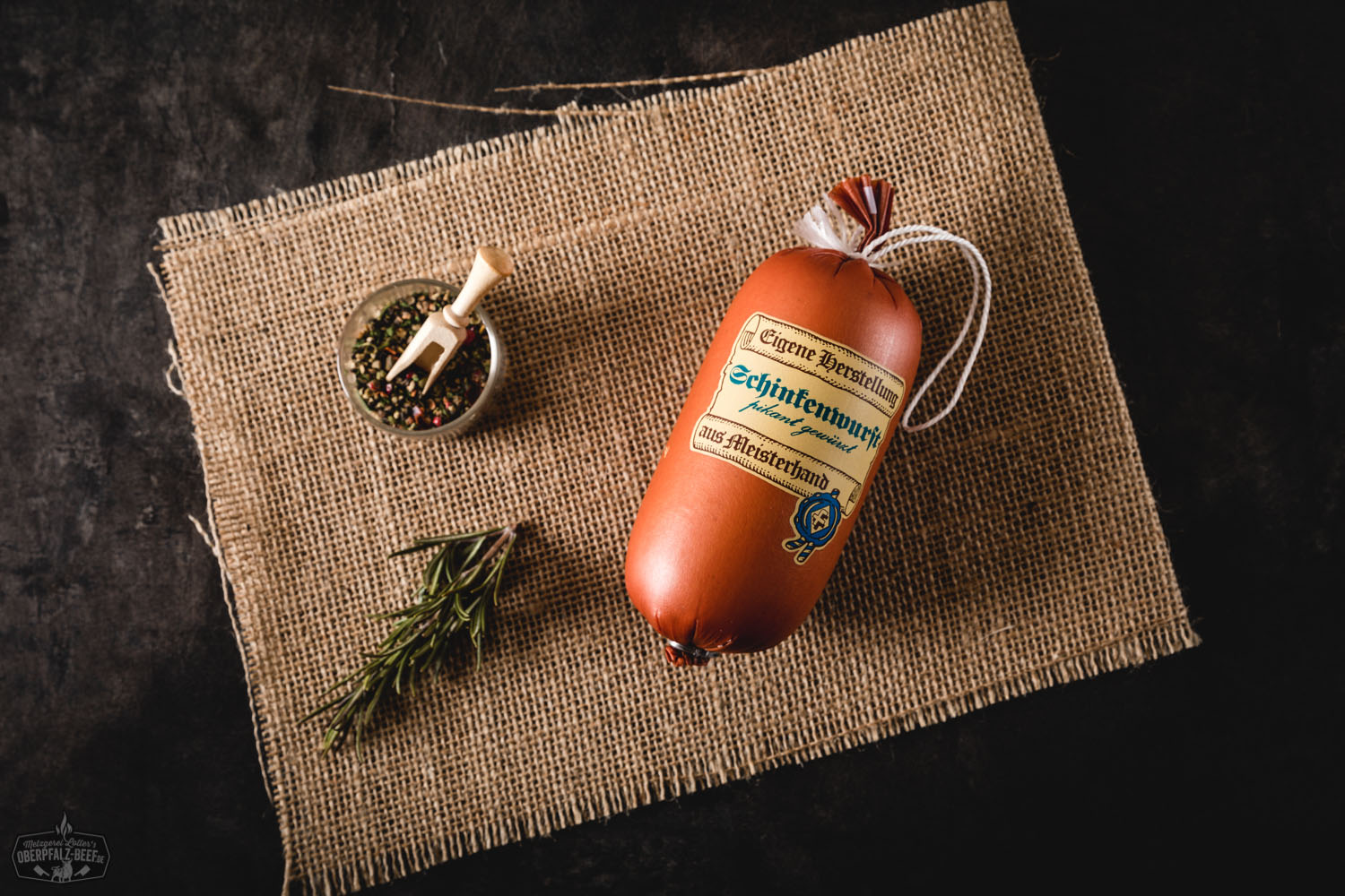 Feine Schinkenwurst in Portionsgröße – Delikatesswurst aus Bayern Feine Schinkenwurst in Portionsgröße, einzeln verpackt in transparenter Folie mit Etikett von Oberpfalz Beef, auf hellem Untergrund platziert – Wurst mit sichtbaren Fleischstücken, ideal für Brotzeit, Delikatessen oder regionale Spezialitäten.