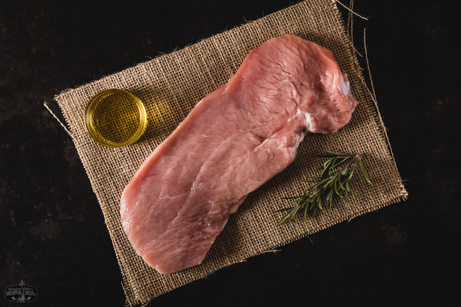 Schnitzel vom Oberpfälzer Milchkalb – Zartes Kalbfleisch regional genießen Goldbraun paniertes Schnitzel vom Oberpfälzer Milchkalb auf weißem Teller, serviert mit Zitronenscheibe, knusprigen Bratkartoffeln und frischer Petersilie – traditionelle bayerische Spezialität, frisch zubereitet und regional gekocht.