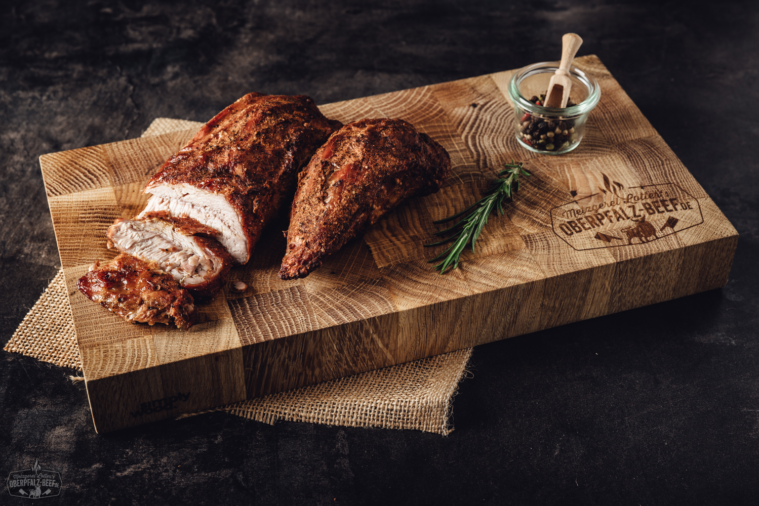 Sous-Vide gegarter Kalbsbraten aus der Schulter – zartes Fleisch online kaufen Kalbsbraten aus der Nuss, fertig gegart im Sous-Vide-Verfahren, saftig aufgeschnitten auf Holzbrett präsentiert, mit dunklem Bratensaft und frischer Kräuterdekoration – zartes Fleisch mit feiner Marmorierung in rustikalem Setting.