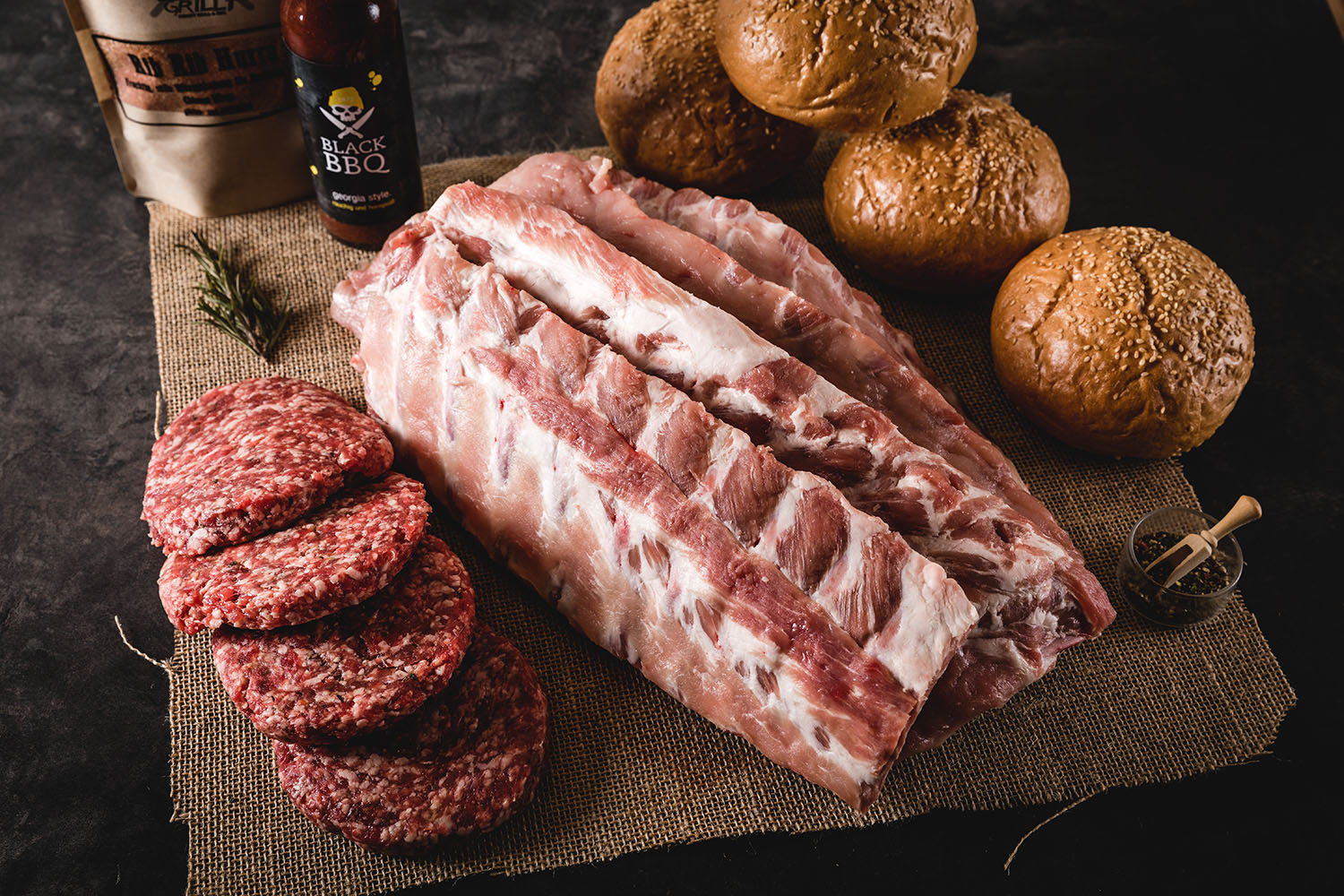 Classic Oberpfalz Beef Baby Back Ribs Burger Paket – Premium BBQ-Fleisch online kaufen Burger-Paket mit Baby Back Ribs, saftigem Rindfleisch-Patty, geschmolzenem Käse, Salat und BBQ-Sauce im Brioche-Bun, angerichtet auf dunklem Holzbrett mit frischen Kräutern – hochwertige Oberpfalz-Beef-Produkte in rustikalem Ambiente.
