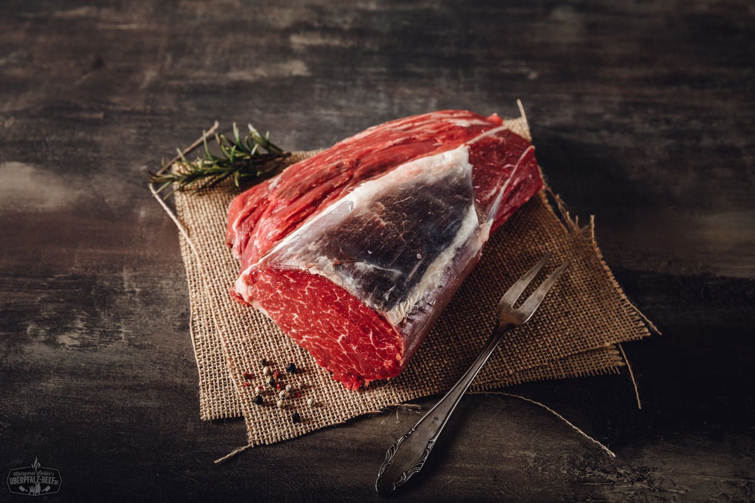 Rinderfiletkopf Wet Aged vom Oberpfalz-Rind – zart gereiftes Premium-Rindfleisch Rinderfiletkopf vom Oberpfalz-Rind, wet-aged gereift, roh und ohne Verpackung auf einem dunklen Untergrund angerichtet – hochwertiges Rindfleisch mit zarter Marmorierung, ideales Premiumstück für Steak-Liebhaber.