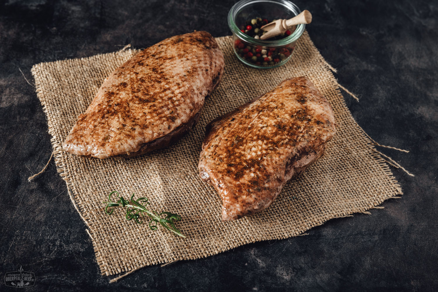 Sous-vide Gänsebrustfilet ohne Knochen – zart vorgegart und servierfertig Vorgegartes Gänsebrustfilet ohne Knochen, zartrosa gegart, mit knuspriger Haut, auf einem Holzbrett angerichtet, umgeben von frischen Kräutern, Orangenscheiben und Bratensauce – hochwertiges Sous-vide-Fleisch aus der Oberpfalz.