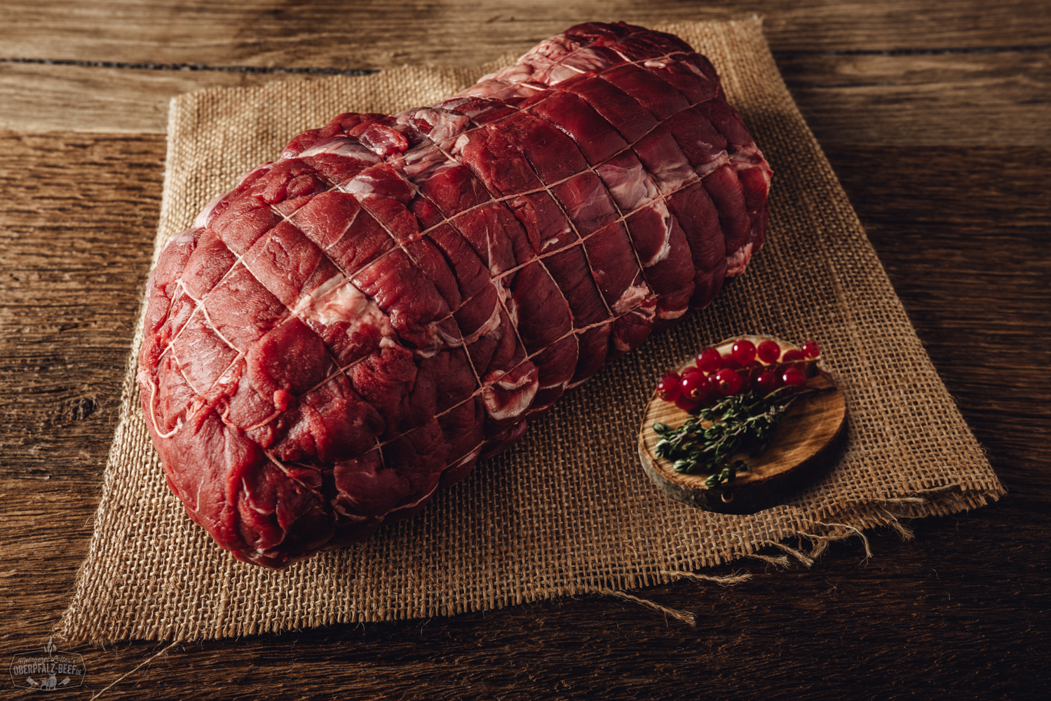 Zwei bayerische Leberknödel im natürlichen Schweinedarm, roh und vakuumverpackt, auf schwarzem Untergrund präsentiert – traditionelles Oberpfälzer Fleischprodukt aus regionaler Metzgerei.