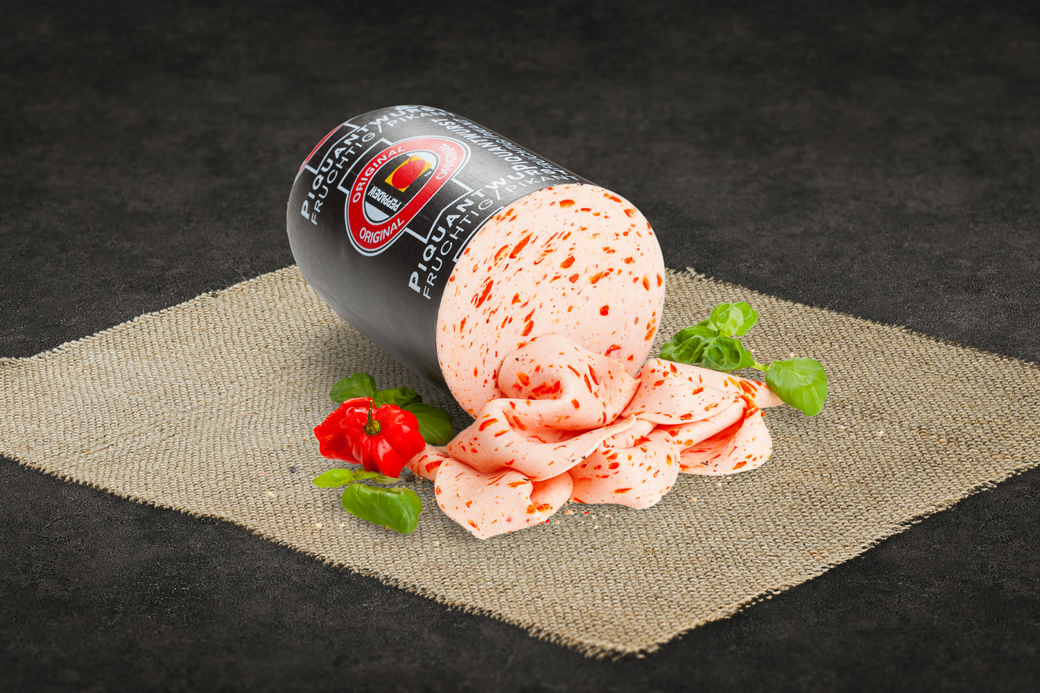 Geschnittene Peppadew-Wurst auf Holzbrett – pikante Delikatesse aus der Oberpfalz Geschnittene Jagdwurst in gleichmäßigen Scheiben auf einem Holzbrett angerichtet, im Hintergrund frische Kräuter und Pfefferkörner – hochwertige Wurstwaren aus der Oberpfalz für Feinschmecker.