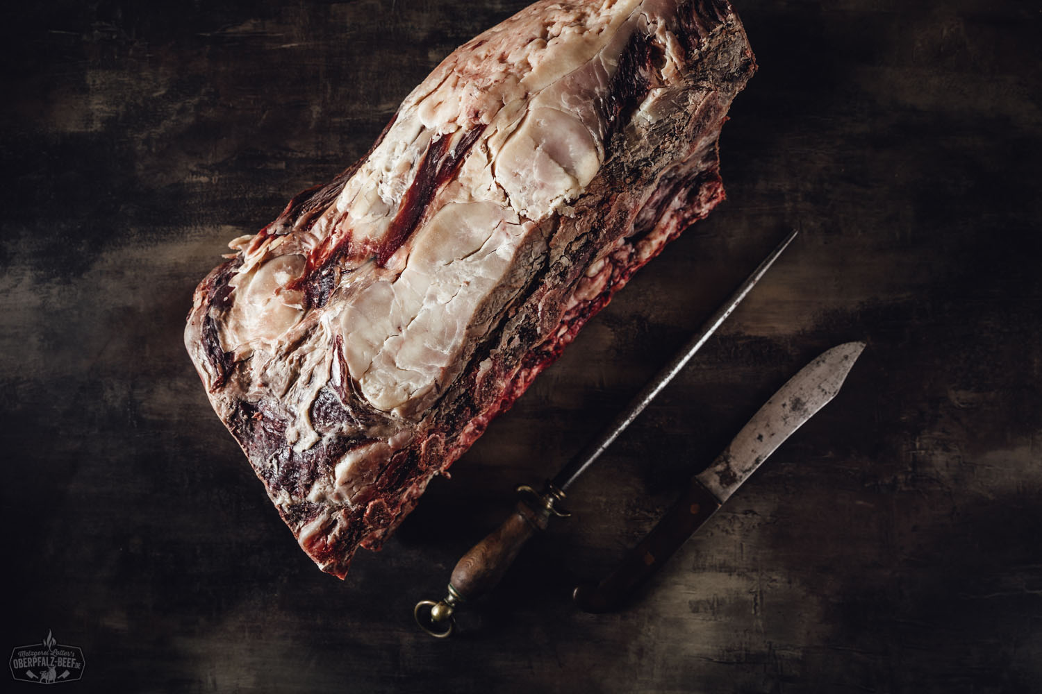 Dry Aged Cote de Boeuf vom Oberpfalz-Rind – Rib Eye am Stück Dry-aged Cote de Boeuf (Rib-Eye) am Stück vom Oberpfalz-Rind auf dunklem Holzbrett, mit sichtbarer Marmorierung und Knochen, hochwertig präsentiert für Premium-Rindfleischgenuss.
