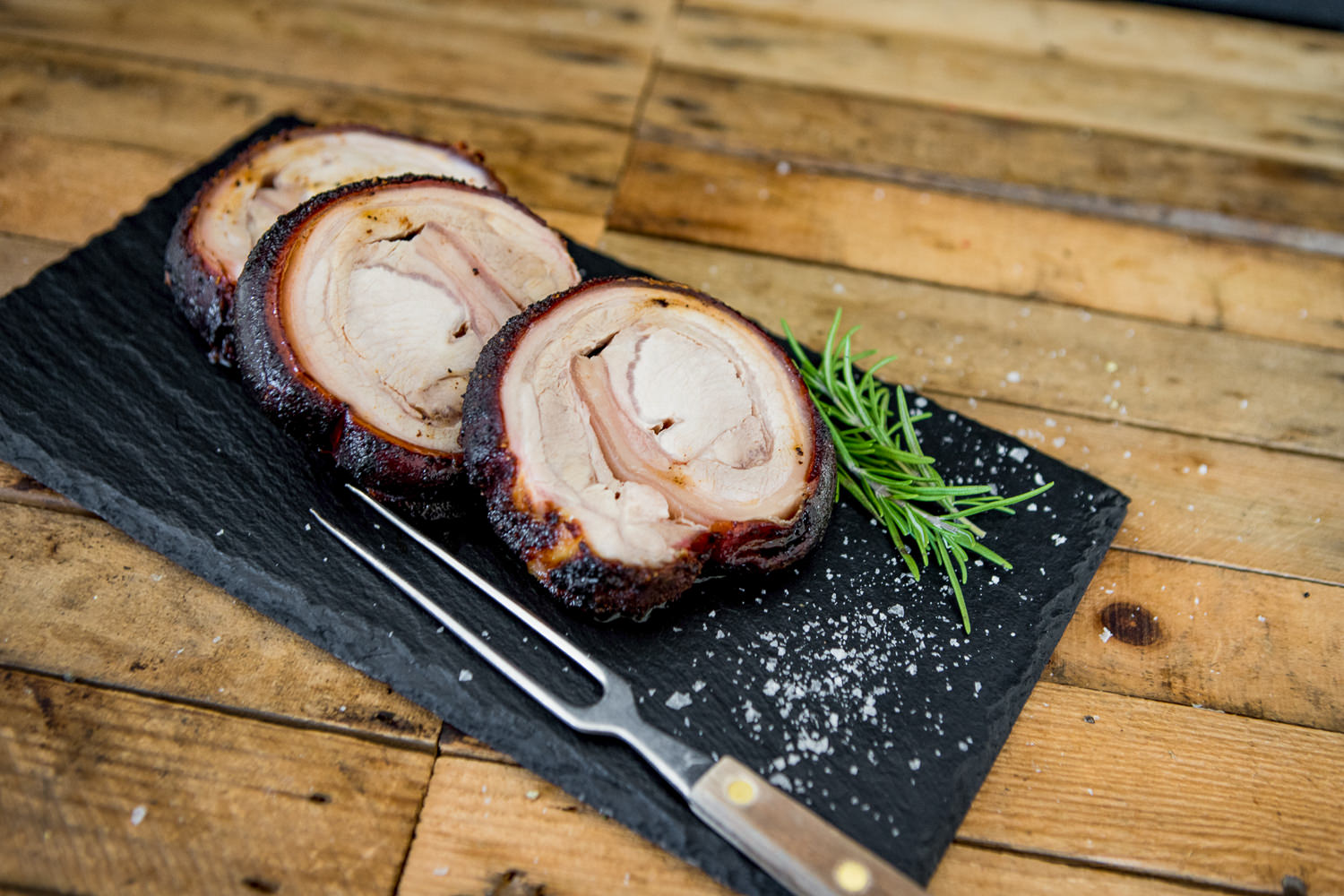 Spanferkelrollbraten vom Oberpfälzer Landschwein – knusprig, groß und ofenfrisch Spanferkelrollbraten vom Oberpfälzer Landschwein, goldbraun knusprig gebraten, aufgeschnitten und saftig auf einem Holzbrett serviert, mit frischen Kräutern und knuspriger Kruste – traditionelles bayerisches Braten-Gericht.
