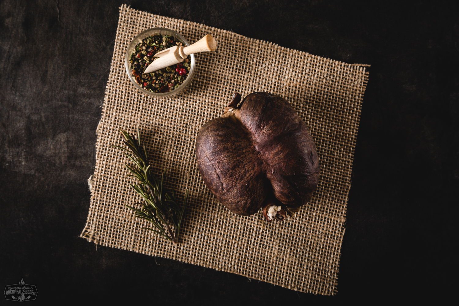 Geräucherte Blutwurst in Scheiben auf Schneidebrett, angerichtet mit frischen Zwiebelringen, Gewürzen und rustikalem Brotmesser – traditionelle bayerische Wurstspezialität in authentischer Holzumgebung.