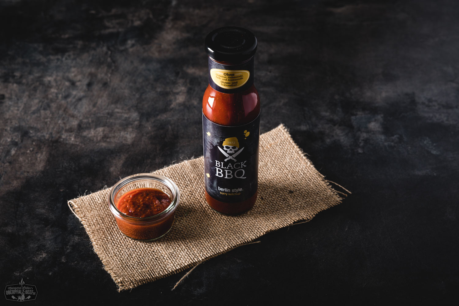 Black BBQ Curry Ketchup Berlin Style – Würzige Grillsauce im Glas Flasche Black BBQ Curry Ketchup im Berlin-Style mit schwarzem Etikett, goldener Schrift und Retro-Design auf rustikalem Holztisch – veganer, würziger Curry-Ketchup als Premium-Grillsauce für BBQ und Streetfood.