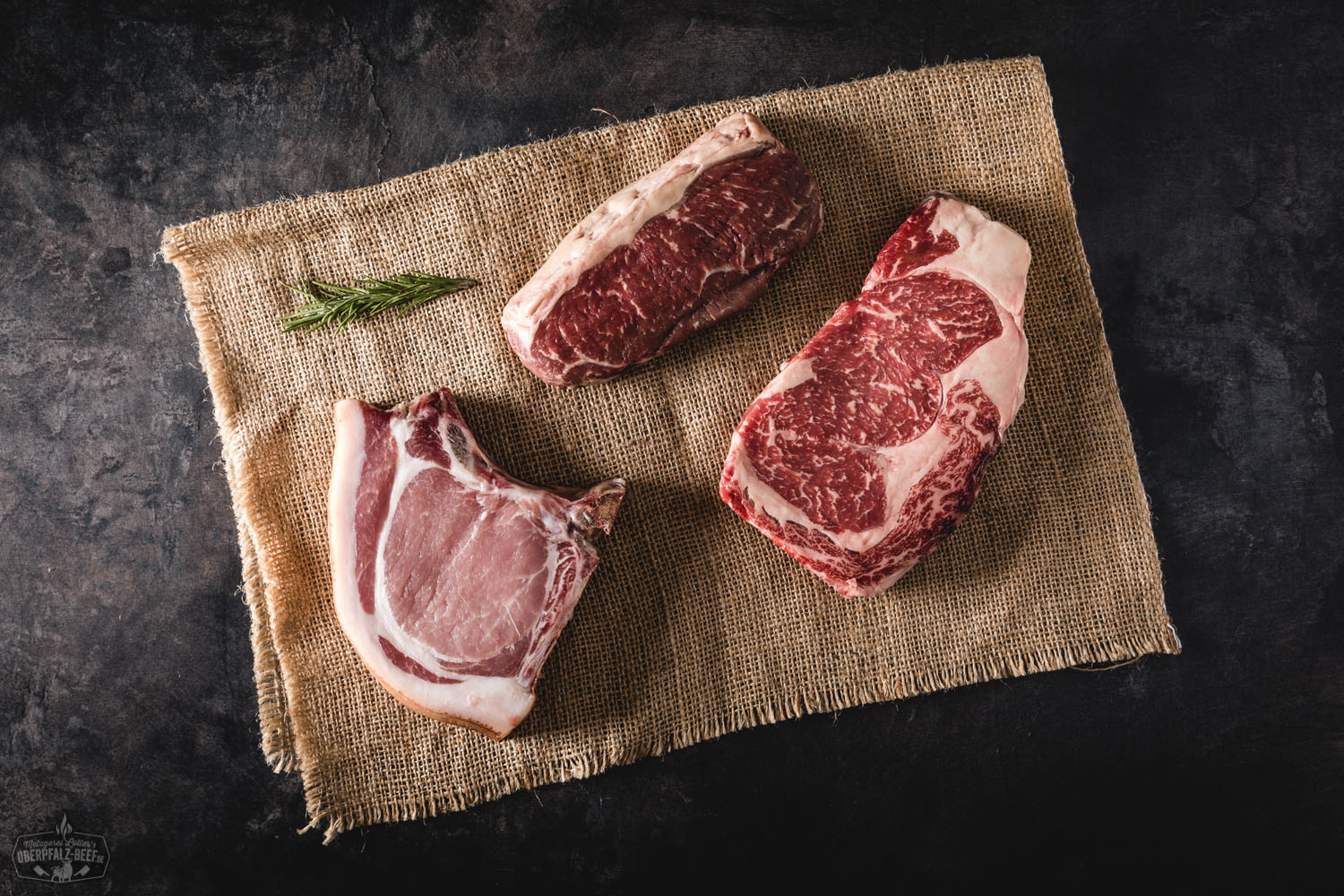 Kennenlernpaket von Oberpfalz Beef: vakuumverpacktes Premium-Rindfleisch auf Holzuntergrund, darunter Ribeye, Rinderhack, Braten, Rouladen, Steaks und Burger-Patties – hochwertiges Fleisch aus regionaler Zucht, appetitlich angerichtet.