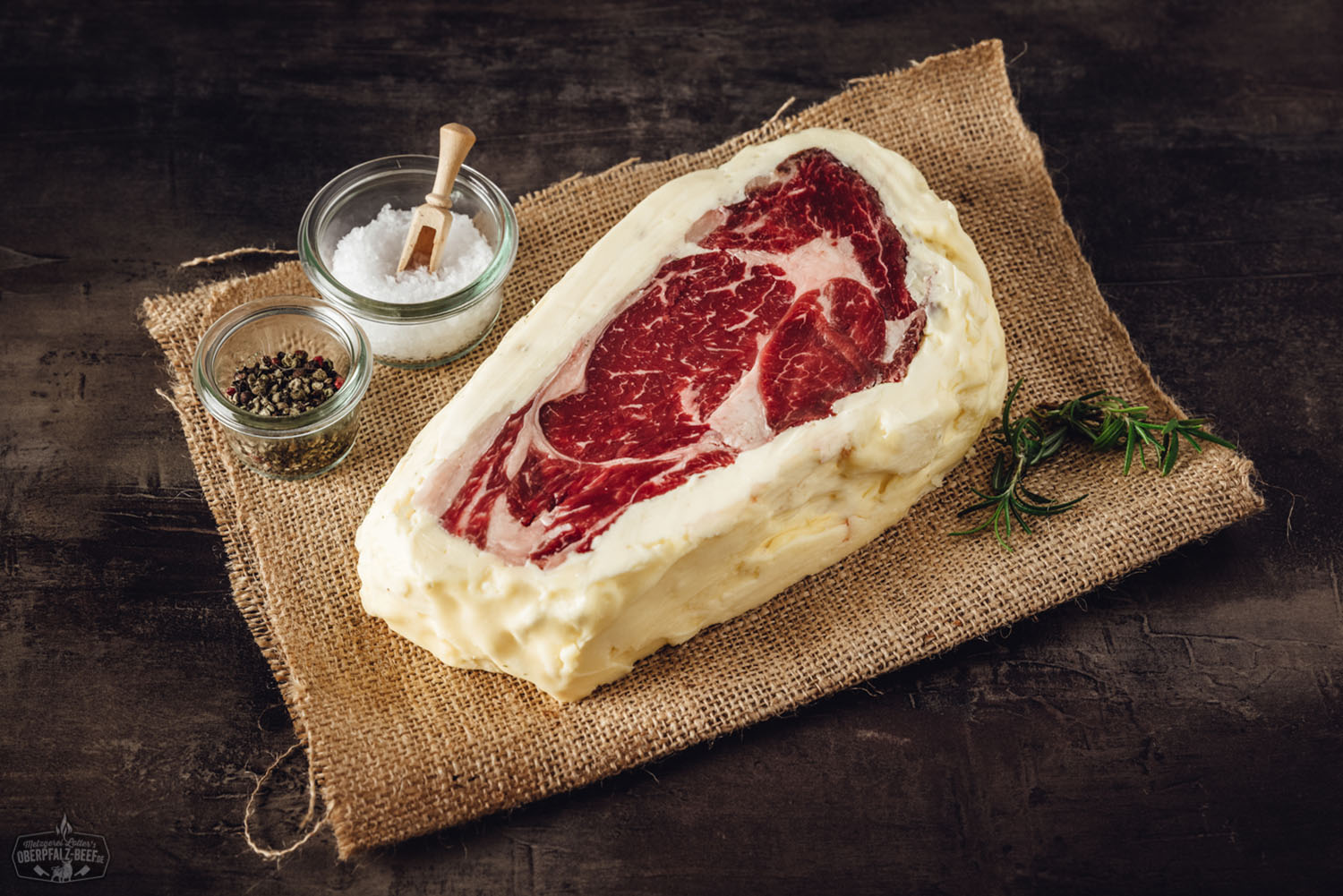 Butter Aged Entrecôte (Rib-Eye Steak) vom Oberpfalz-Rind – Premium Qualität aus Bayern Rohes Entrecôte-Rib-Eye-Steak vom Oberpfalz-Rind auf dunklem Untergrund, marmoriertes, saftiges Rindfleisch in hochwertiger Butter-Aged-Qualität, ideale Struktur und Fettverteilung für Premium-Steakgenuss.
